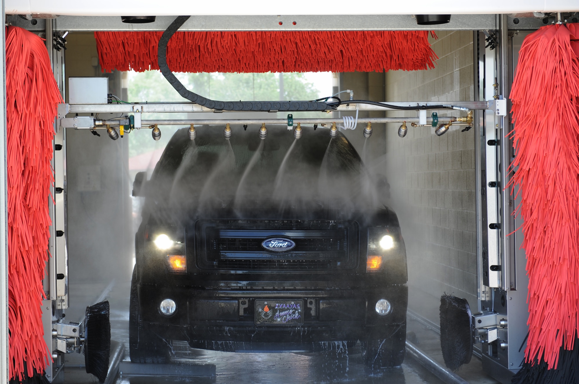 Staff Sgt. Pamela Bradford, 2nd Maintenance Group command staff, drives her vehicle through the Auto Hobby Shop's Car Wash on Barksdale Air Force Base, La., June 2, 2014. The Auto Hobby Shop's Car Wash offers four different wash options which include a combo wash, soft wash, touch free and basic wash.  (U.S. Air Force photo/Senior Airman Benjamin Gonsier)