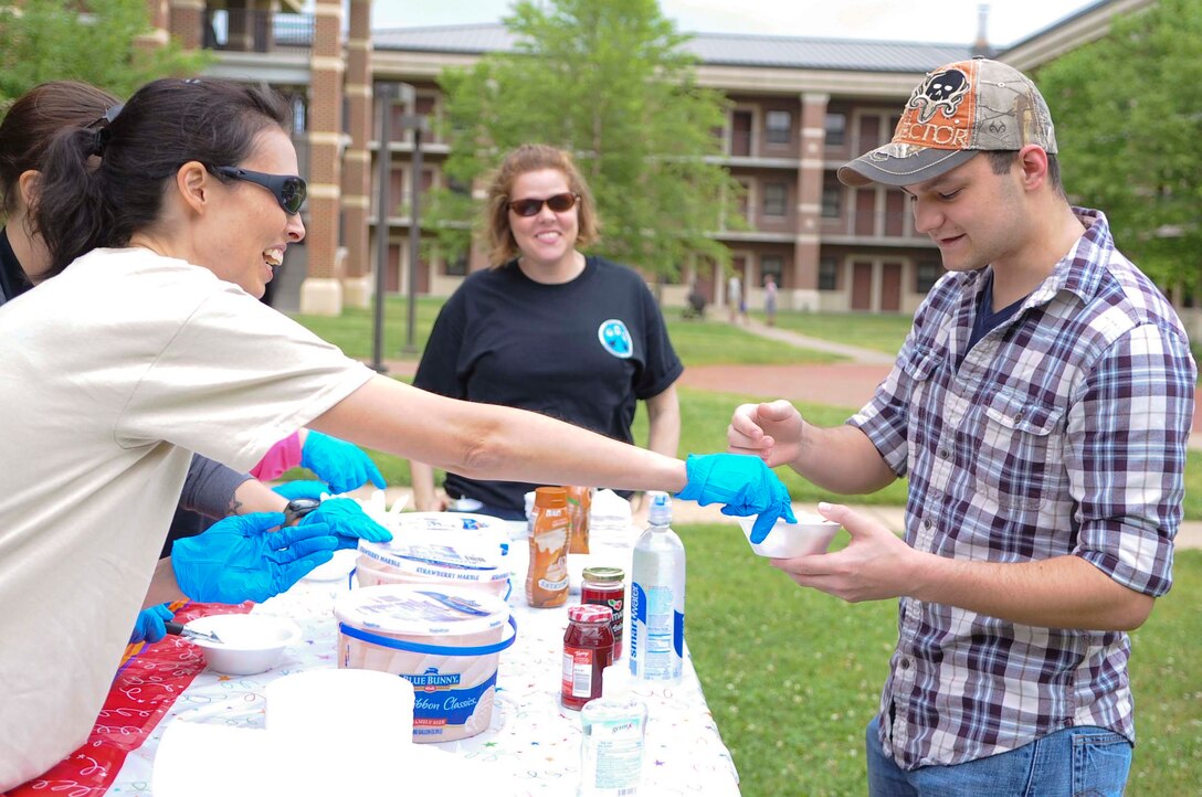 U.S. Air Force Master Sgt. Lisa Moose, Air Combat Command A3 Command Executive Administrator, hands an Airman a bowl of ice cream during an ice cream social at Langley Air Force Base, Va., May 30, 2014. In addition to free ice cream and music for dormitory residents, the social gave Airmen a chance to interact with one another and senior enlisted members. (U.S. Air Force photo by Senior Airman Austin Harvill/Released) 