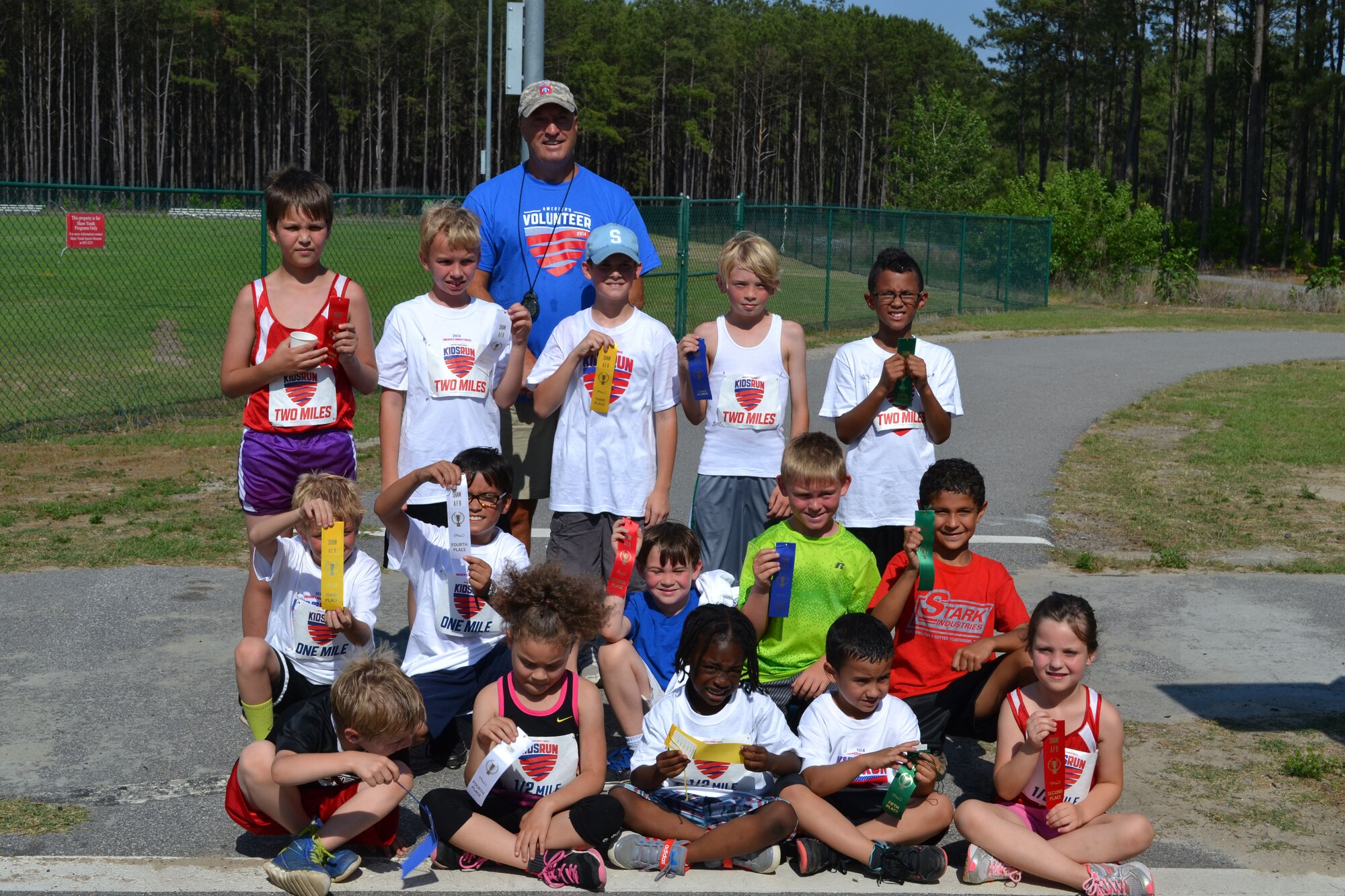 The winners from Shaw Air Force Base’s 2014 Americas Kids Run take a group photo with Larry Stegall, 20th Force Support Squadron Youth Sports director, May 22, 2014, Shaw AFB, S.C. The winners of the race all received a ribbon along with an America’s Kids Run t-shirt. (courtesy photo)