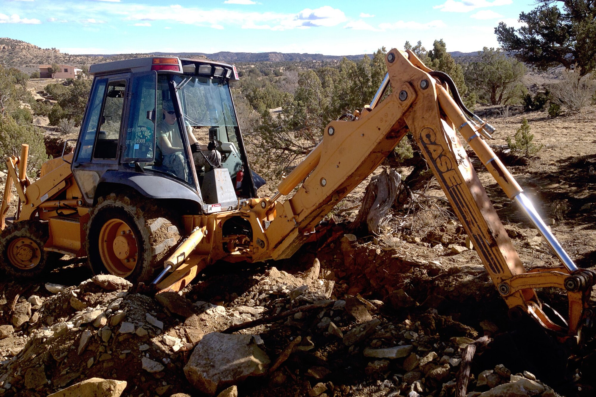 Senior Airman Edward Black, 434th Civil Engineer Squadron pavements and equipment operator, digs a utilities trench near Gallup, N.M., on March 3, 2014. Airmen from Grissom Air Reserve Base, Ind., constructed houses recently for Native American families in New Mexico as part of a training opportunity.  (U.S. Air Force photo/Master Sgt. Josh Moormann)