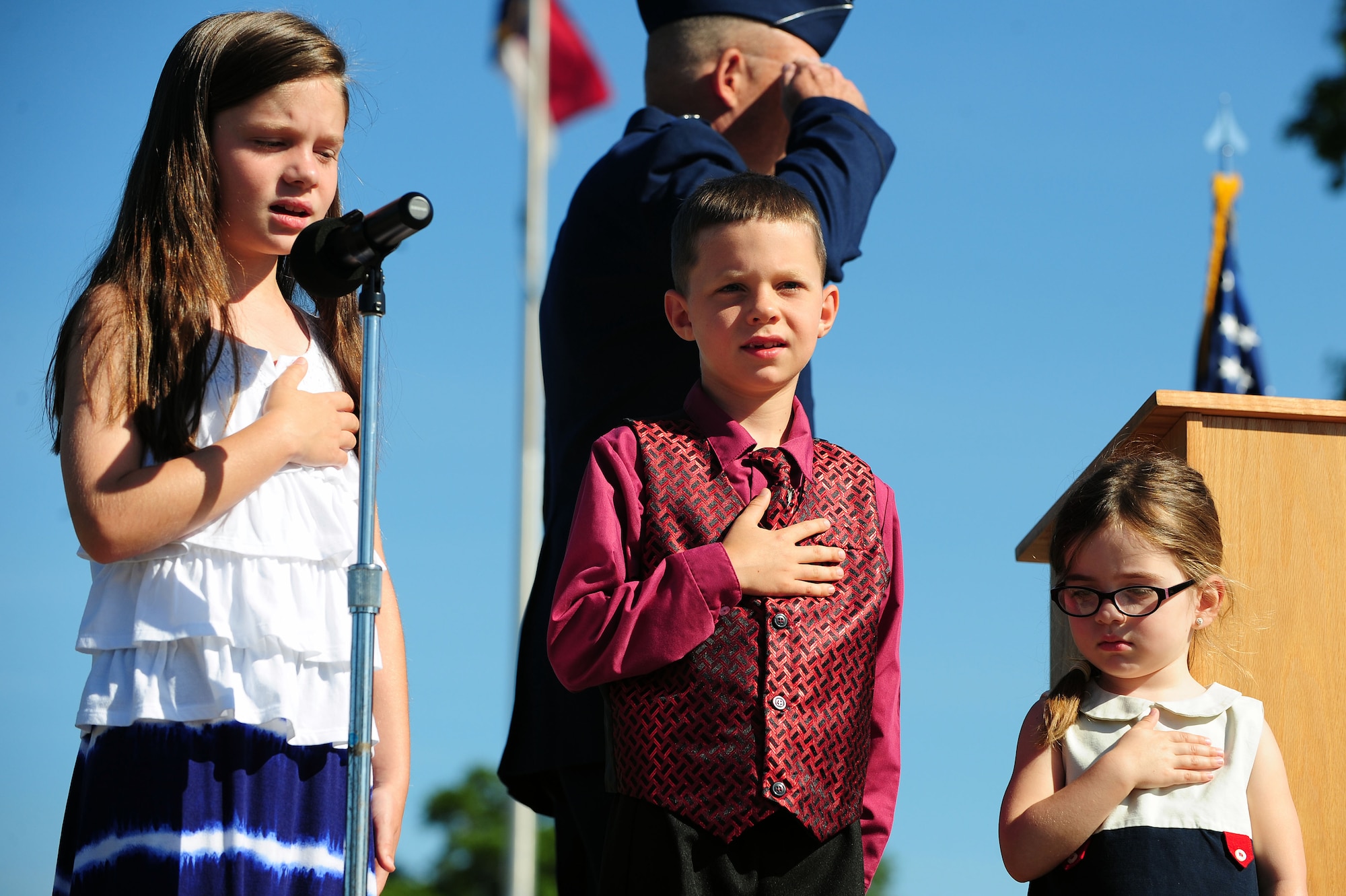 Children of the incoming and outgoing 4th Fighter Wing commanders sing the national anthem, June 2, 2014, at Seymour Johnson Air Force Base, North Carolina. Col. Jeannie Leavitt relinquished command to Col. Mark Slocum following a two year assignment as the 4th FW commander. (U.S. Air Force photo/Senior Airman John Nieves Camacho)