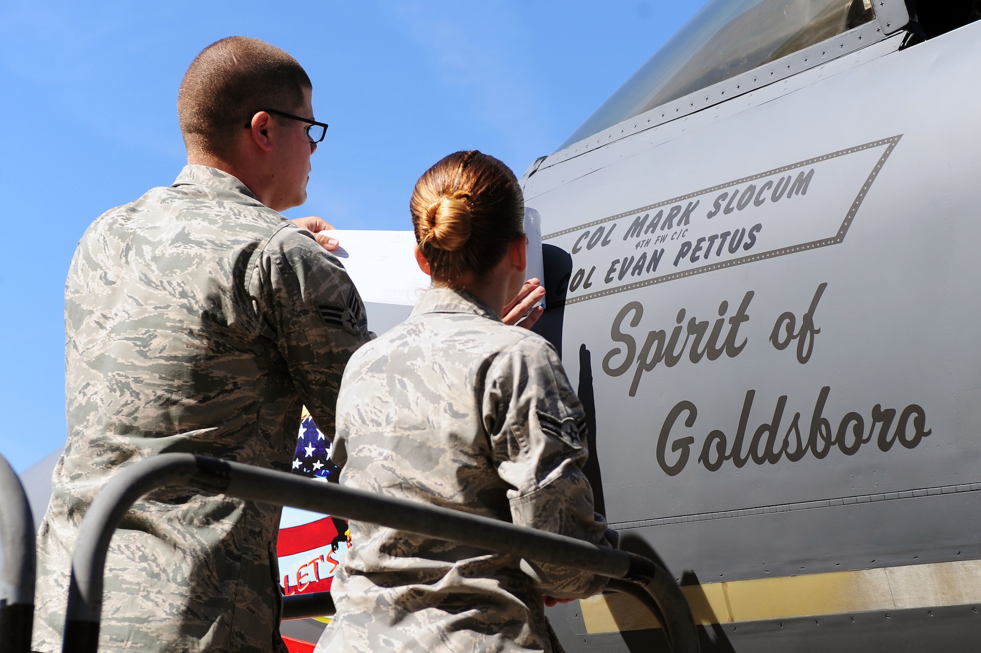 Senior Airman Christopher Oetzel and Airman 1st Class Sarah Seymour, 4th Aircraft Maintenance Squadron crew chiefs, unveil the flagship on Col. Mark Slocum’s F-15E Strike Eagle aircraft, June 2, 2014, at Seymour Johnson Air Force Base, North Carolina. Slocum assumed command following Col. Jeannie Leavitt’s two-year tenure as 4th FW commander. (U.S. Air Force photo/Senior Airman John Nieves Camacho)