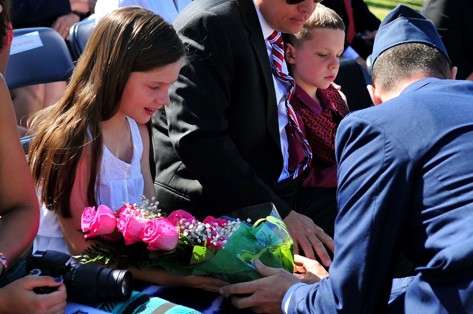 The child of Col. Jeannie Leavitt receives a bouquet of roses from her mother during the 4th Fighter Wing change of command ceremony, June 2, 2014, at Seymour Johnson Air Force Base, North Carolina.  Leavitt relinquished command to Col. Mark Slocum following a two year assignment as the 4th FW commander. (U.S. Air Force photo/Airman 1st Class Shawna L. Keyes)