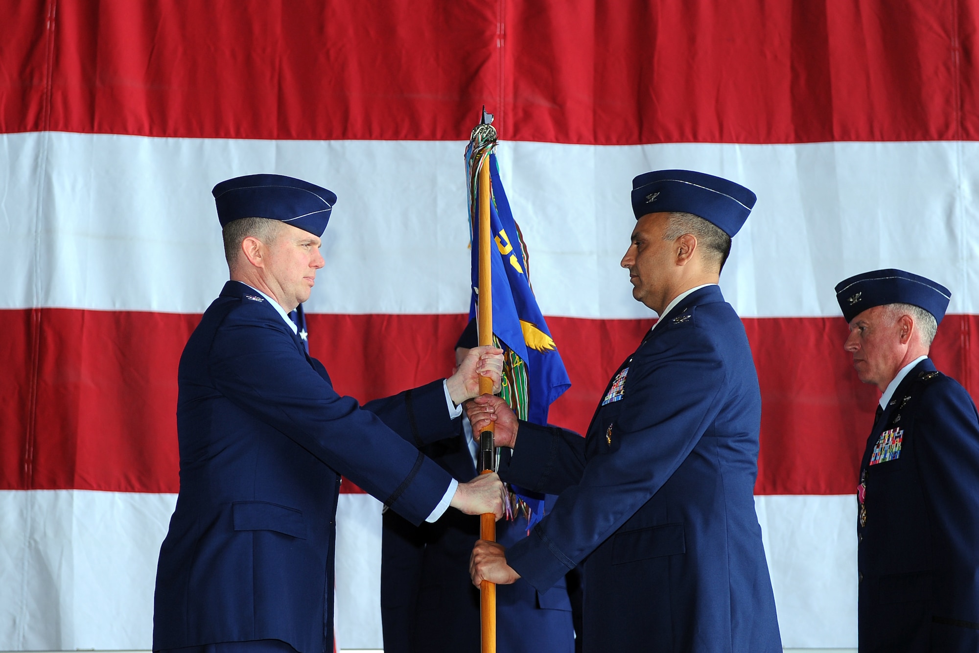U.S Air Force Col. Mohan Krishna accepts the guidon from U.S. Air Force Col. Gregory Guillot, 55th Wing commander, as he assumes command of the 55th Operations Group. The 55th OG is the largest operations group in the Air Force with 3,200 Airmen in 12 squadrons and one detachment, operating 33 aircraft. (U.S. Air Force photo by Josh Plueger/Released)