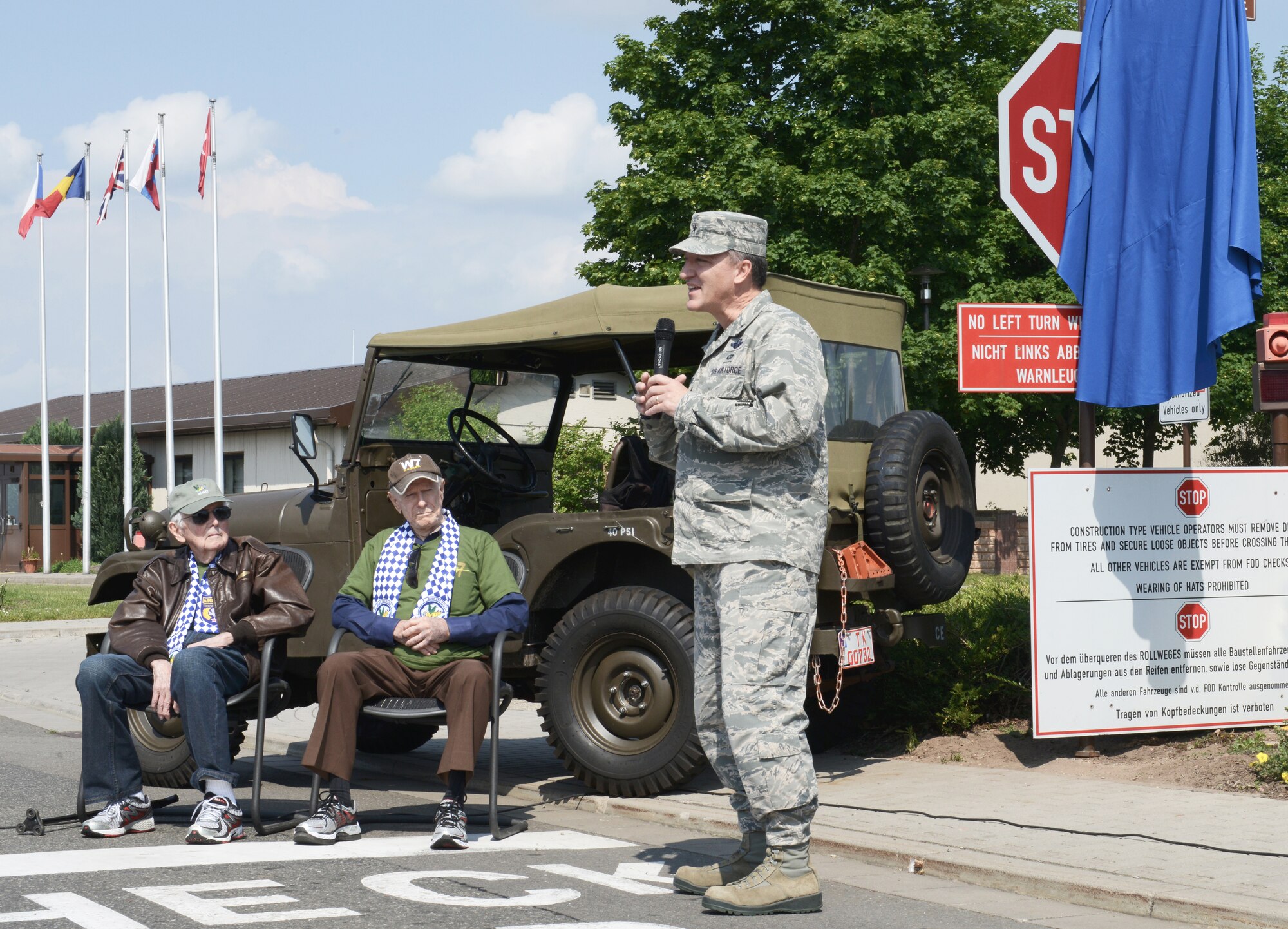 William Prindible and Julian Rice, former World War II pilots, listen as Brig. Gen. Patrick X. Mordente, 86th Airlift Wing commander, speaks about how important it is to remember the past in order to secure the future during a street-naming ceremony on Ramstein Air Base, Germany, June 2, 2014. The street was named Skytrain Lane after the C-47, the same kind of aircraft that both Prindible and Rice flew during the D-Day invasion. Prior to the ceremony, Prindible and Rice spoke to a crowded group of Airmen in the Hercules Theater on base about personal experiences related to the D-Day invasion of Normandy, France. (U.S. Air Force photo/Staff Sgt. Travis Edwards)