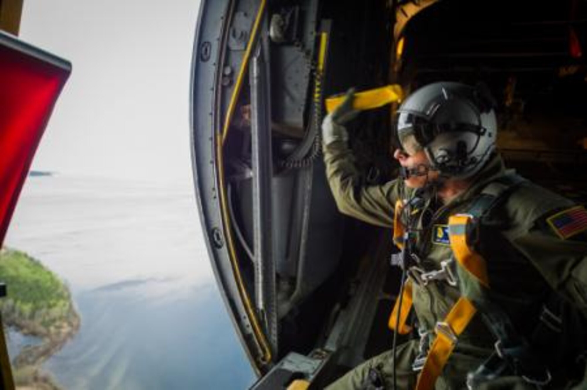 U.S. Air Force Senior Airman Adam Strom, C-130 Hercules loadmaster with the 94th Airlift Wing, Dobbins Air Reserve Base, Ga., throws a paper streamer out the starboard troop door during Maple Flag 47 in Edmonton/Cold Lake, Alberta, Canada, May 30, 2014. Maple Flag is an international exercise designed to enhance the interoperability of C-130 aircrews, maintainers and support specialists in a simulated combat environment. (U.S. Air Force photo by Master Sgt. John R. Nimmo, Sr./Released)