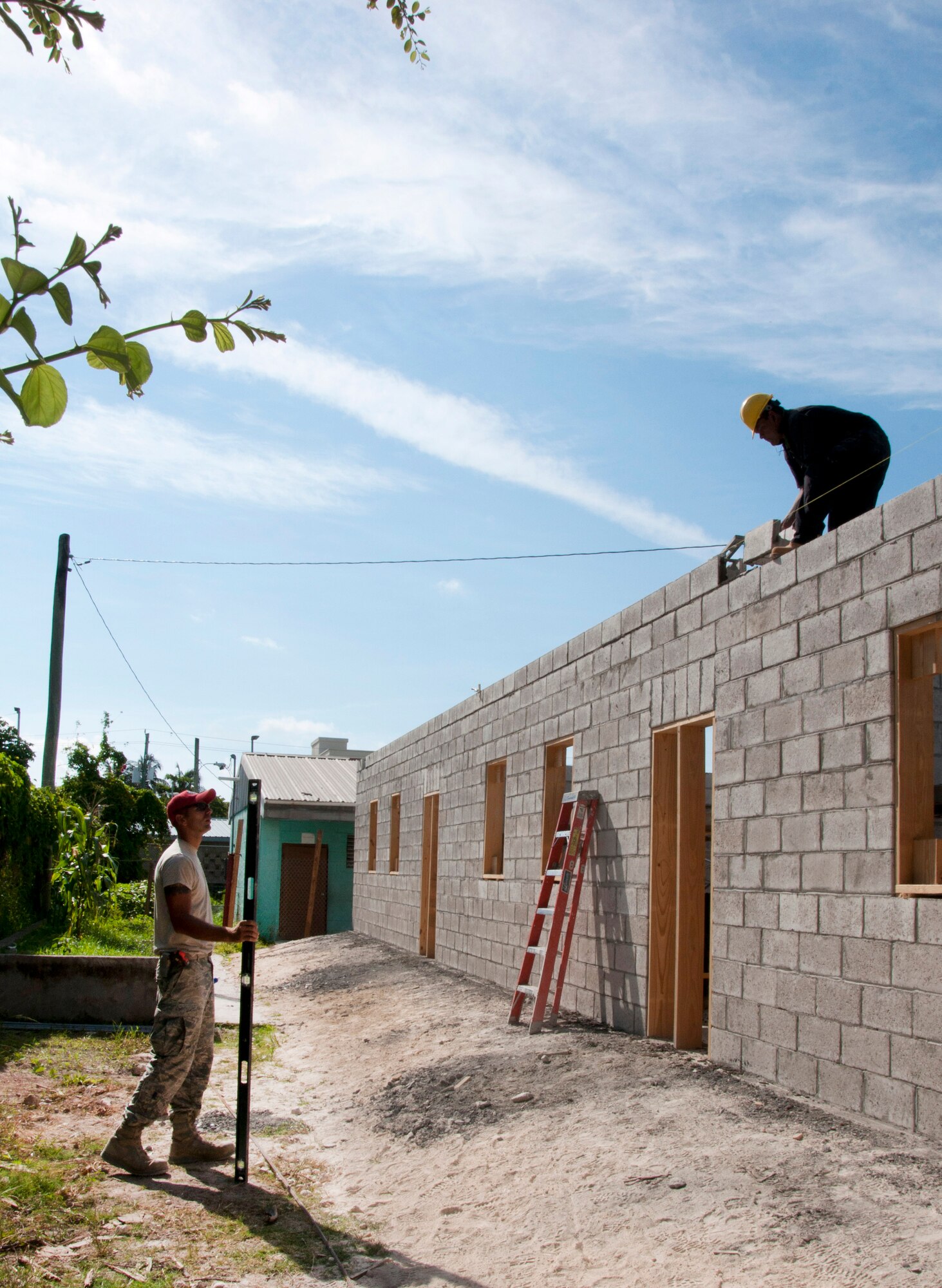 U.S. Air Force Tech. Sgt. Piotr Wilk, New Horizons project manager at the Stella Maris School Belize Academy for the Deaf construction site, left, speaks with a member of the Belize Defence Force assisting with construction at the site April 23, 2014, in Belize City, Belize. BDF and U.S. service members are working together to build five school buildings and one medical facility throughout Belize during New Horizons Belize 2014. New Horizons is an annual event coordinated between the U.S. and the host nation to provide mutual training opportunities. (U.S. Air Force photo by Tech. Sgt. Kali L. Gradishar/Released)
