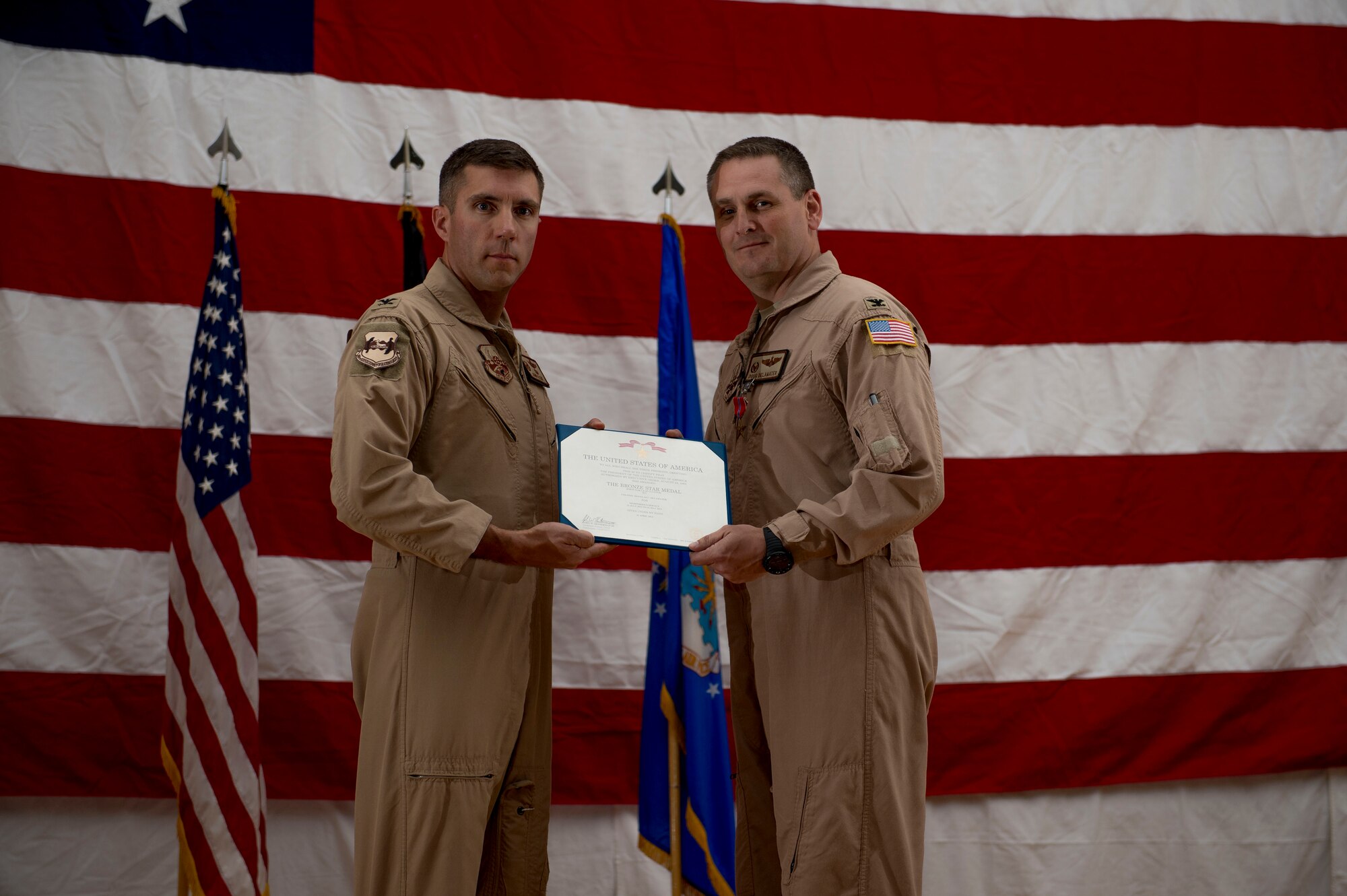 U.S. Air Force Col. John Klein presents Col. Douglas DeLaMater with the Bronze Star June 1, 2014 at an undisclosed location in Southwest Asia. DeLaMater was awarded the medal just before relinquishing command of the 386th Expeditionary Operations Group during a change of command ceremony. (U.S. Air Force photo by Staff Sgt. Jeremy Bowcock)