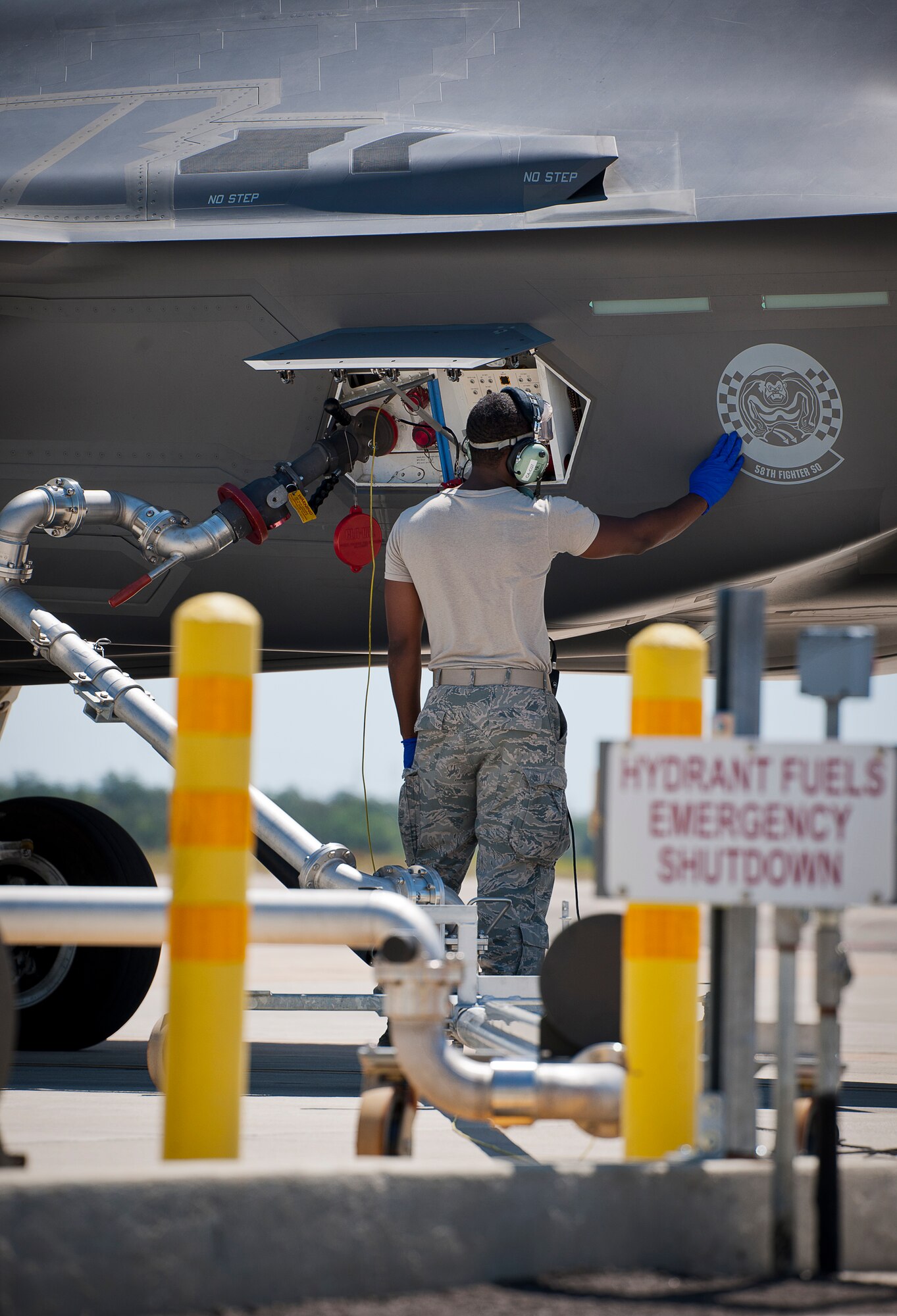Staff Sgt. Mark Freeman, 33rd Aircraft Maintenance Squadron, touches the 58th Fighter Squadron logo on the side of an F-35A Lightning II during hot pit refueling at Eglin Air Force Base, Fla.  All of the F-35 variants use the refueling areas in conjunction with the 96th Logistics Readiness Squadron’s fuels flight.  (U.S. Air Force photo/Samuel King Jr.)