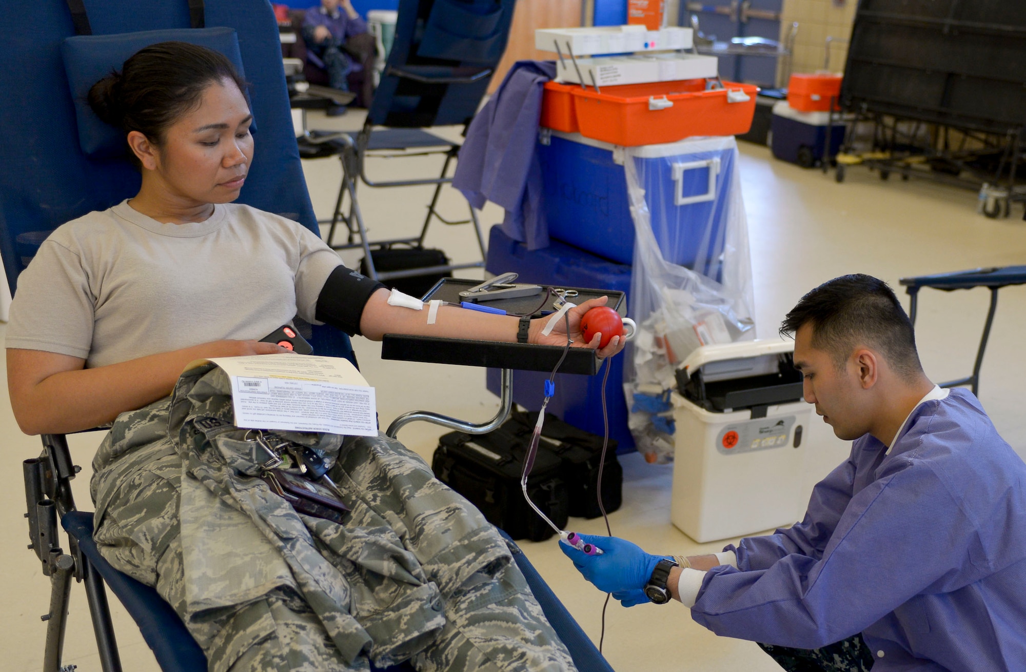 U.S. Navy Hospital Corpsman 3rd Class Arwin Mejia, Naval Medical Center Portsmouth laboratory technician, draws blood from U.S. Air Force 1st Lt. Jewelyn Delacruz, 633rd Medical Operations Squadron clinical nurse, during the Armed Services Blood Program Blood Drive at Langley Air Force Base, Va., May 28, 2014. The Armed Service Blood Program is responsible for all active duty personnel worldwide, family members and dependents in military medical facilities. They also send blood donations downrange to Service members every week. (U.S. Air Force photo by Senior Airman Connor Estes/Released) (photo cropped and sharpened for effect)
