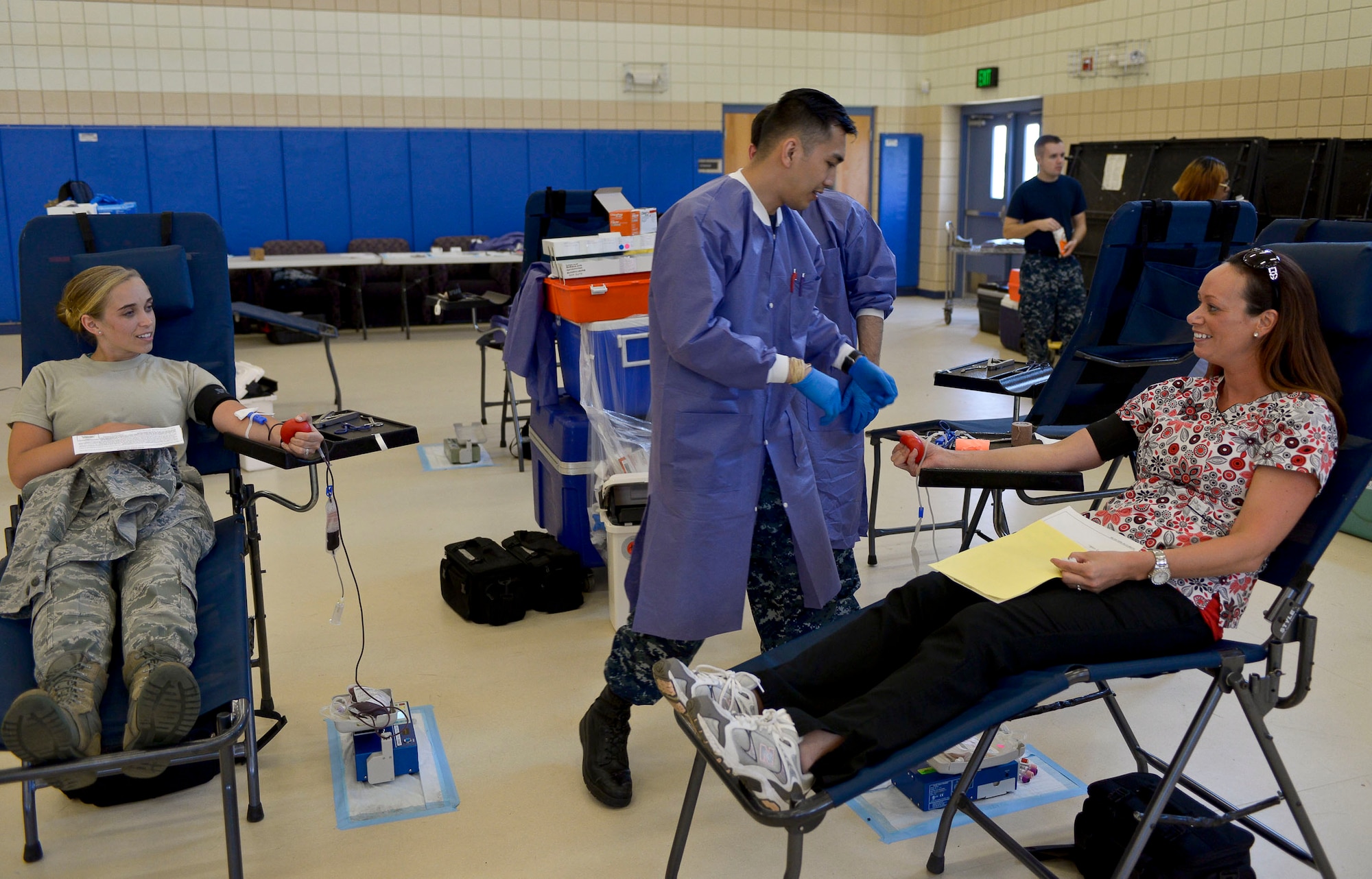 U.S. Air Force Airman 1st Class Chelsea Ellman, left, 633rd Medical Operations Squadron medical technician, and Courtney Winter, right, 633rd MDOS license practical nurse, donate blood during the Armed Services Blood Program Blood Drive at Langley Air Force Base, Va., May 28, 2014. Donations from the blood drive are used to support military hospitals and Service members downrange. (U.S. Air Force photo by Senior Airman Connor Estes/Released) (photo cropped and sharpened for effect)