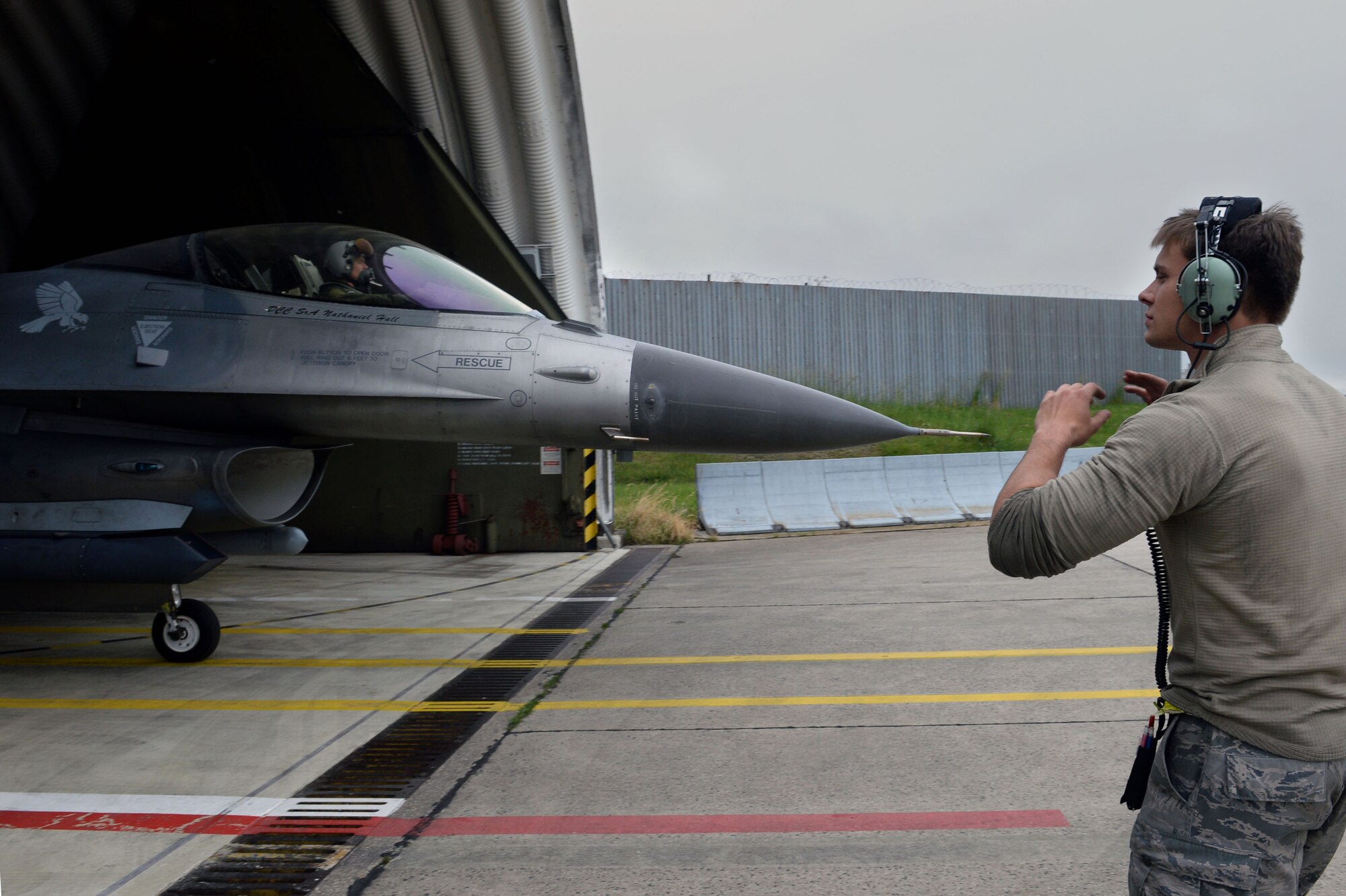 U.S. Air Force Airman 1st Class Kyle Sumpter, 480th Aircraft Maintenance Unit crew chief from Fredrick, Md., marshals U.S. Air Force Capt. Eric Emerson, 480th Fighter Squadron pilot from Smyrna, Del., out of a hardened shelter at Spangdahlem Air Base, Germany, before heading to the U.S. Air Force Aviation Detachment, Poland,  May 30, 2014. Airmen from the 480th FS and 606th Air Control Squadron will be supporting this final rotation for this fiscal year as well as exercise Baltic Operations 2014. (U.S. Air Force photo by Senior Airman Alexis Siekert/Released)  