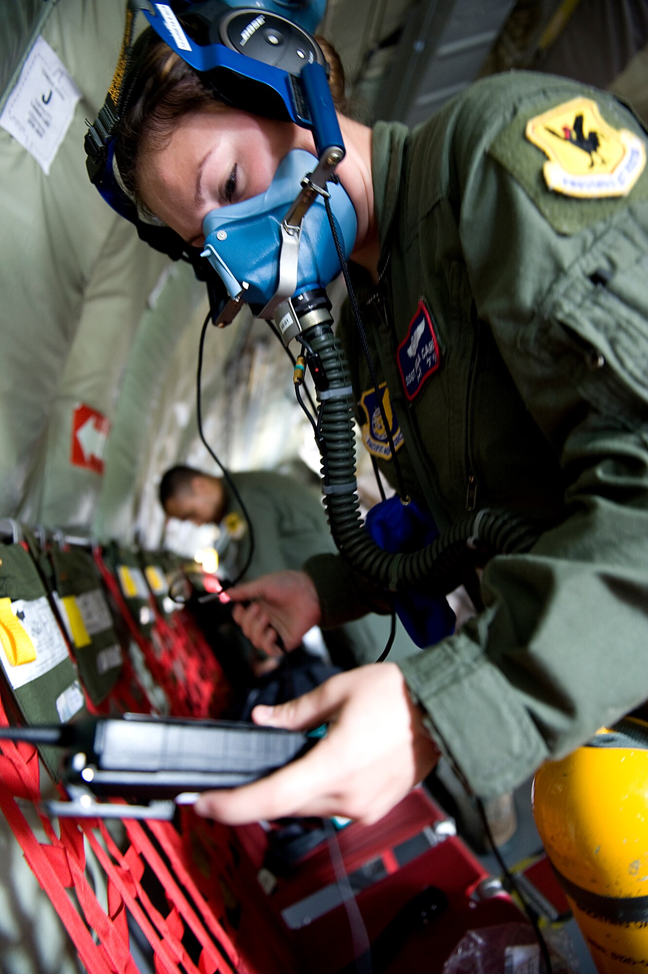 U.S. Air Force Staff Sgt. Carla Carey, 18th Aeromedical Evacuation Squadron aeromedical evacuation technician, inspects her oxygen equipment before a training flight on Kadena Air Base, Japan, May 16, 2014. While 909th Air Refueling Squadron, the 18th AES is frequently employed to oversee the safe transportation of patients within the Pacific area of responsibility. (U.S. Air Force photo by Senior Airman Maeson L. Elleman)