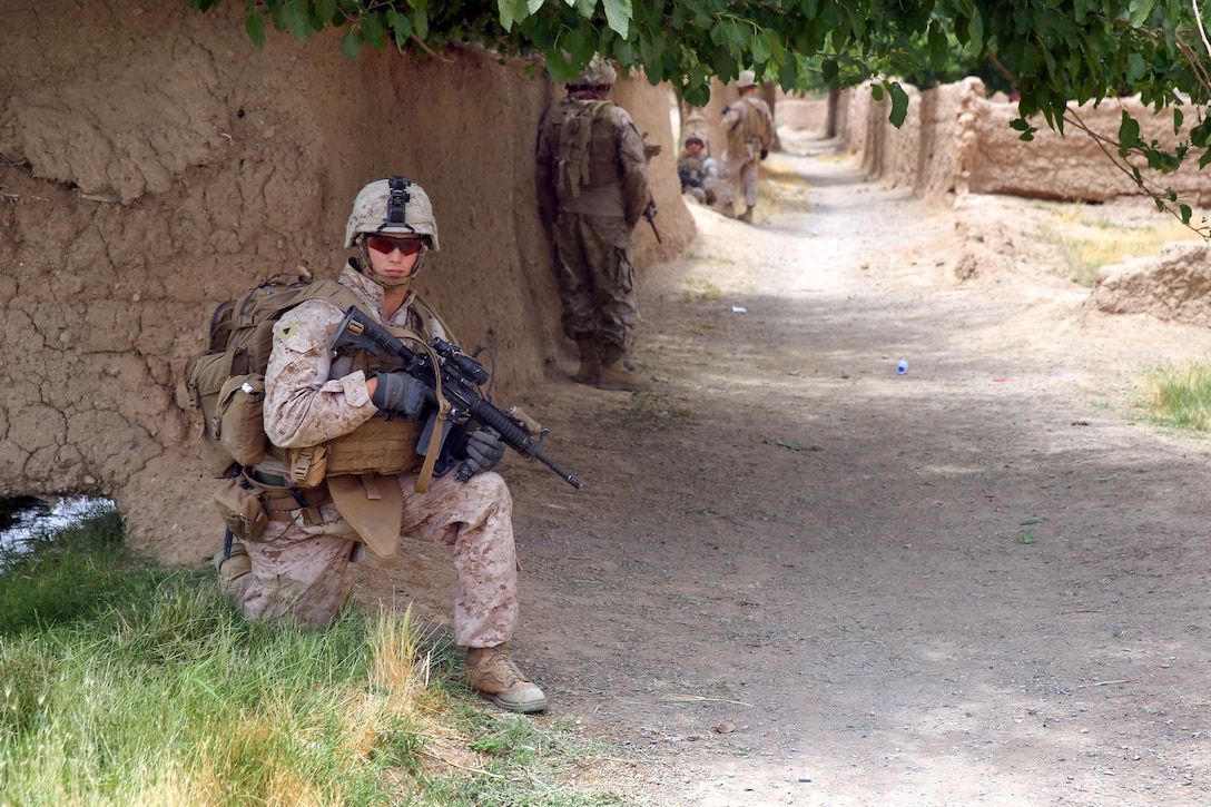 U.S. Marine Corps Cpl. Cody Evans, foreground, provides security as U.S. Marines return to a patrol base during a mission in Larr village in Helmand province, Afghanistan, May 15, 2014. Evans, a squad leader, is assigned to Bravo Company, 1st Battalion, 7th Marine Regiment.