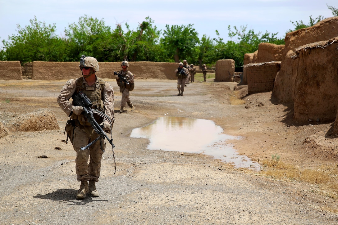 U.S. Marine Corps Lance Cpl. Cody Kelley patrols with an M240B medium machine gun during a mission in Larr village in Helmand province, Afghanistan, May 15, 2014. Kelley, a machine gunner, is assigned to Bravo Company, 1st Battalion, 7th Marine Regiment.