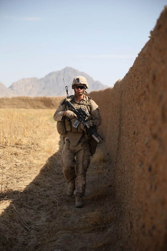 U.S. Marine Corps Lance Cpl. Derl Curry III patrols during a mission in Larr village in Helmand province, Afghanistan, May 22, 2014. Curry, a joint forward observer, is assigned to Weapons Company, 1st Battalion, 7th Marine Regiment.  