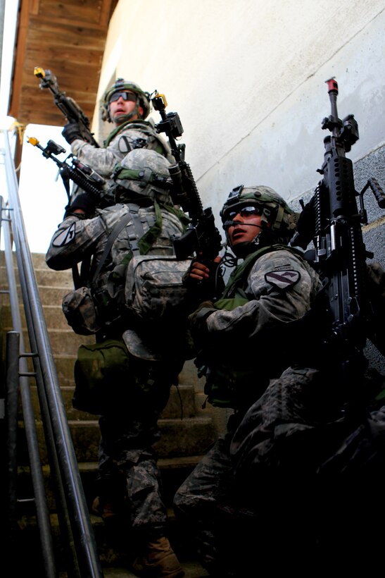 U.S. soldiers move up stairs before entering a building while clearing a town during a partnered training exercise as part of Exercise Combined Resolve II at the Joint Multinational Readiness Center in Hohenfels, Germany, May 22, 2014.