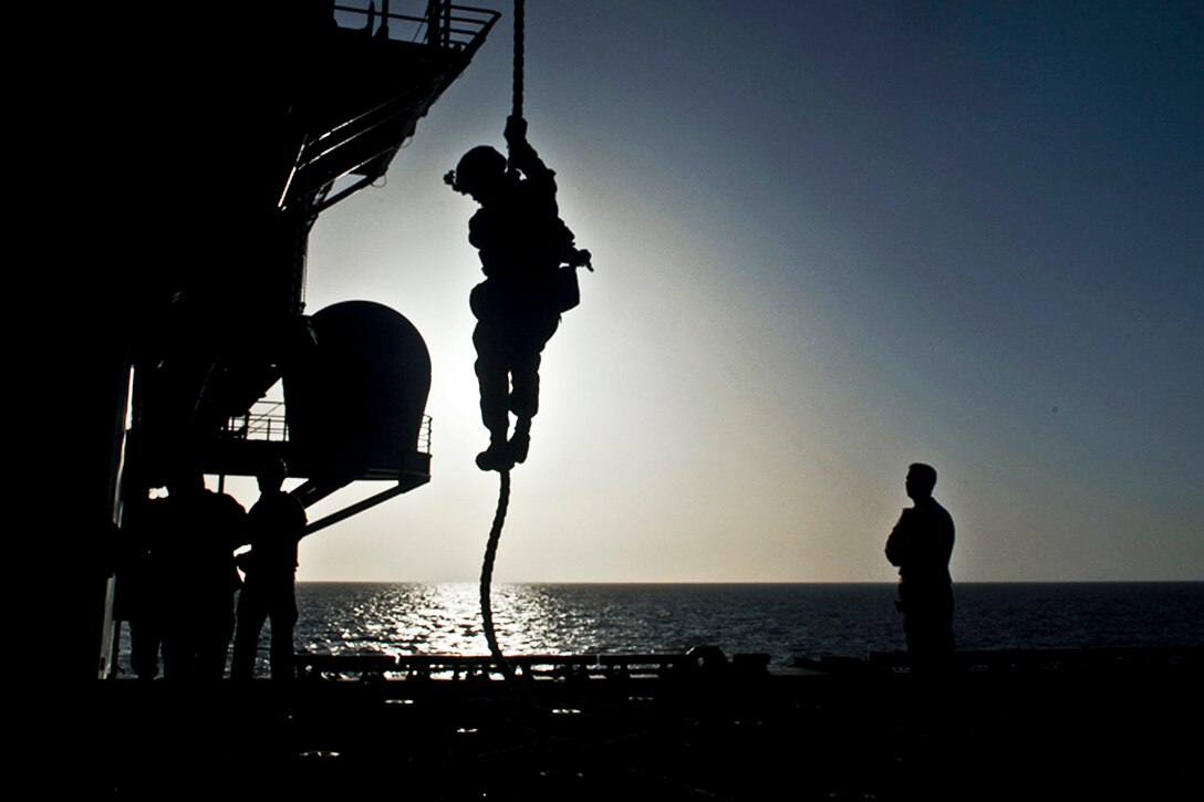 A U.S. Marine assigned to the 11th Marine Expeditionary Unit fast ropes from the back of a helicopter onto the aircraft elevator of the USS Makin Island in the Arabian Sea, May 4, 2012. The Makin Island is deployed in support of maritime security operations and theater security cooperation efforts in the U.S. 5th Fleet area of responsibility.  
