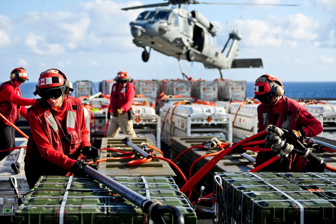 U.S. Navy Airman Kaley R. Vercande, left, rigs a sling on the flight deck of the aircraft carrier USS George H.W. Bush during an ordnance transfer with the USNS Lewis and Clark, a dry cargo and ammunition ship, in the Atlantic Ocean, April 30, 2012. The George H.W. Bush was conducting carrier qualifications.  
