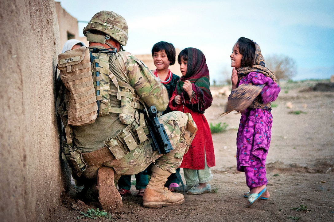U.S. Army Sgt. Joshua Smith talks to a group of Afghan children during a combined patrol clearing operation in Afghanistan's Ghazni province, April 28, 2012. Smith is assigned to the 82nd Airborne Division’s 2nd Battalion, 504th Parachute Infantry Regiment, 1st Brigade Combat Team.  
