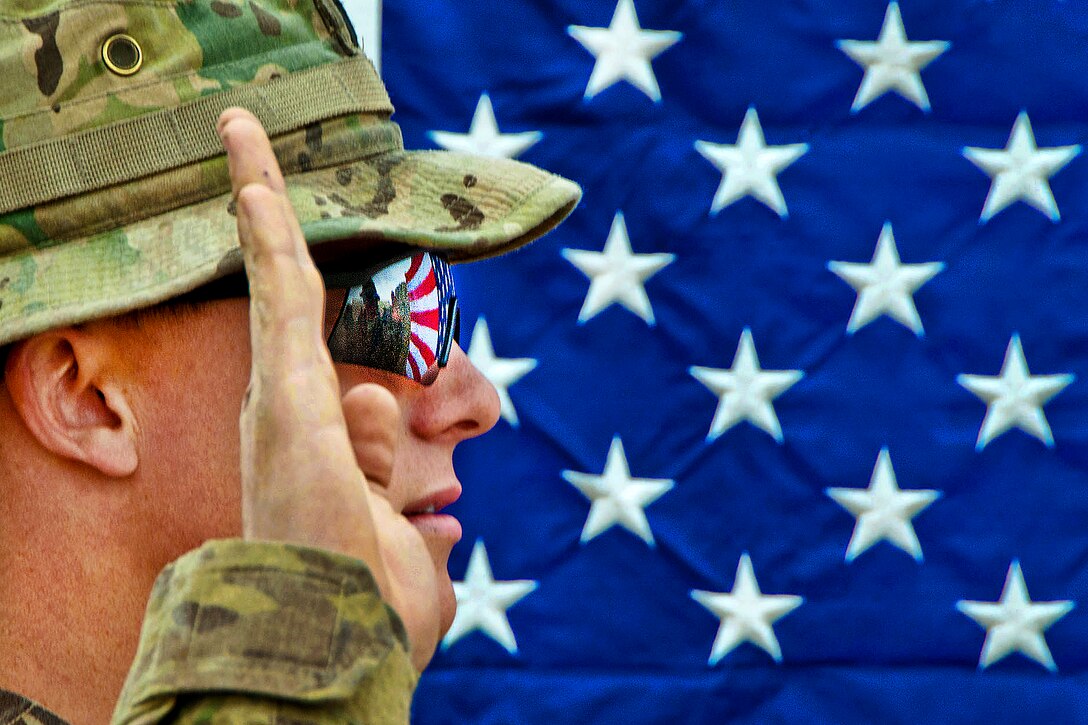 The American flag reflects in the glasses of an U.S. Army officer as he reenlists as a paratrooper on Combat Outpost Qara Baugh in Afghanistan's Ghazni province, April 22, 2012. The soldier is assigned to the 82nd Airborne Division’s 1st Brigade Combat Team.  
