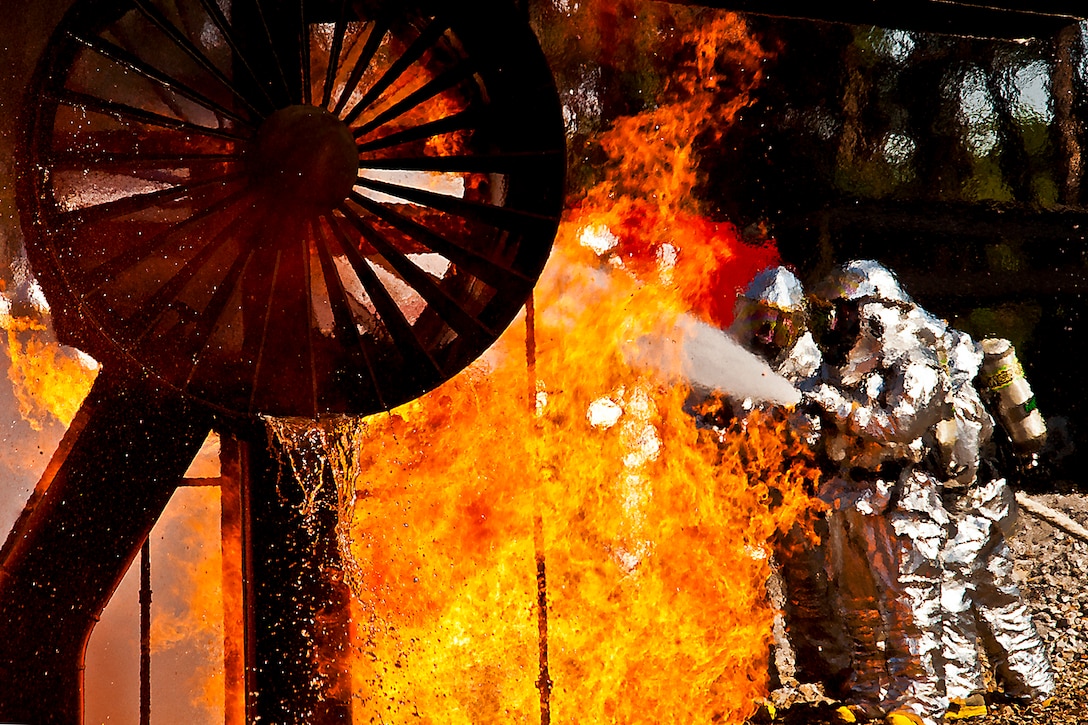 A team of firefighters spray a blazing engine during an aircraft fire training exercise at Hurlburt Field, Fla., April 13, 2012. More than 10 of Duke Field's firemen braved the flames of the aircraft burn pit for the annual refresher training. The firefighters are assigned to the 919th Special Operations Wing.  
