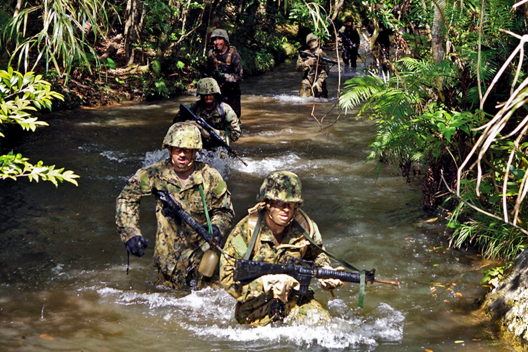 U.S. Marines and sailors run through a stream at the endurance course at the Jungle Warfare Training Center on Camp Gonsalves, Okinawa, Japan, April 8, 2012. The Marines and sailors are assigned to Combat Logistics Regiment 37, 3rd Marine Logistics Group, 3rd Marine Expeditionary Force, and Naval Mobile Construction Battalion 40, 31st Seabee Readiness Group. The course includes numerous water obstacles. 
