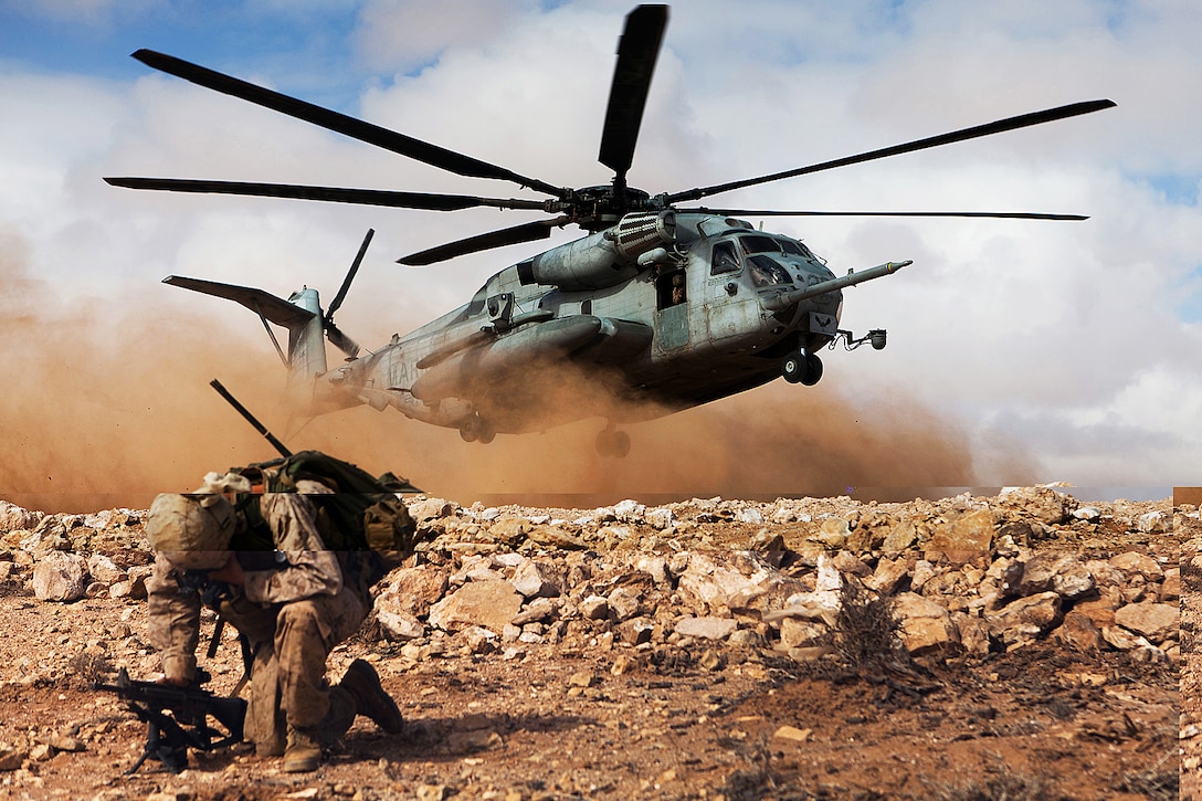 A U.S. Marine shields his face from flying debris kicked up by the rotor wash of a CH-53E Super Stallion helicopter during a rehearsal of the final exercise of Exercise African Lion 2012 on Cap Draa, Morocco, April 16, 2012. The Marines are assigned to the 24th Marine Expeditionary Unit.  
