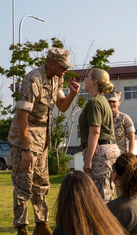 Sgt. Maj. Coleman R. Kinzer corrects at Katherine A. West, Headquarters and Headquarters Squadron Jane Wayne Day participant, for not standing while addressing him aboard Marine Corps Air Station Iwakuni, Japan, May 31, 2014. West is also the family readiness officer for H&HS and coordinator of the event.