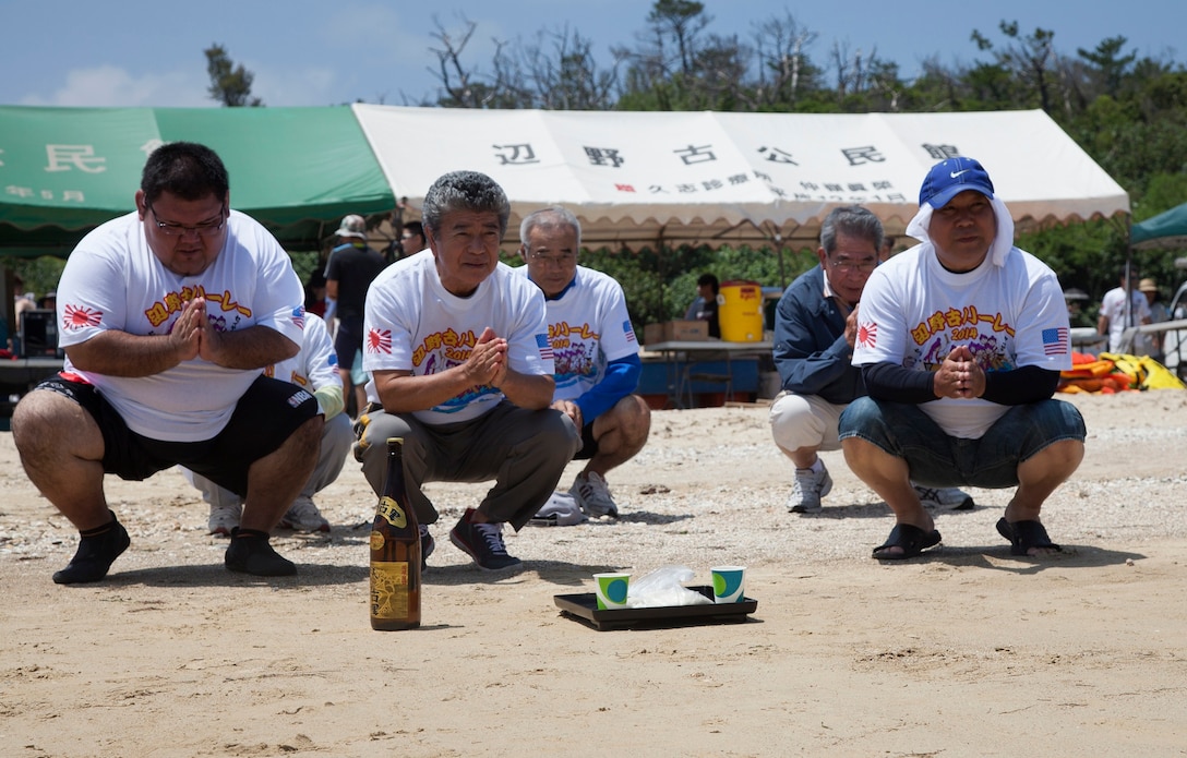 Munekatsu Kayo, second from left, leads the opening prayer to begin the Henoko Dragon Boat Races May 25 at Matsuda-No-Hama Beach. More than 30 teams participated in the 400-meter dash on the water. The boat races were traditionally performed for the god of the sea, to ask that the ocean provide an abundant harvest of seafood, and most importantly to request the safety of the fishermen. Kayo is the district mayor of Henoko. (U.S. Marine Corps photo by Sgt. Jose O. Nava/Released)  