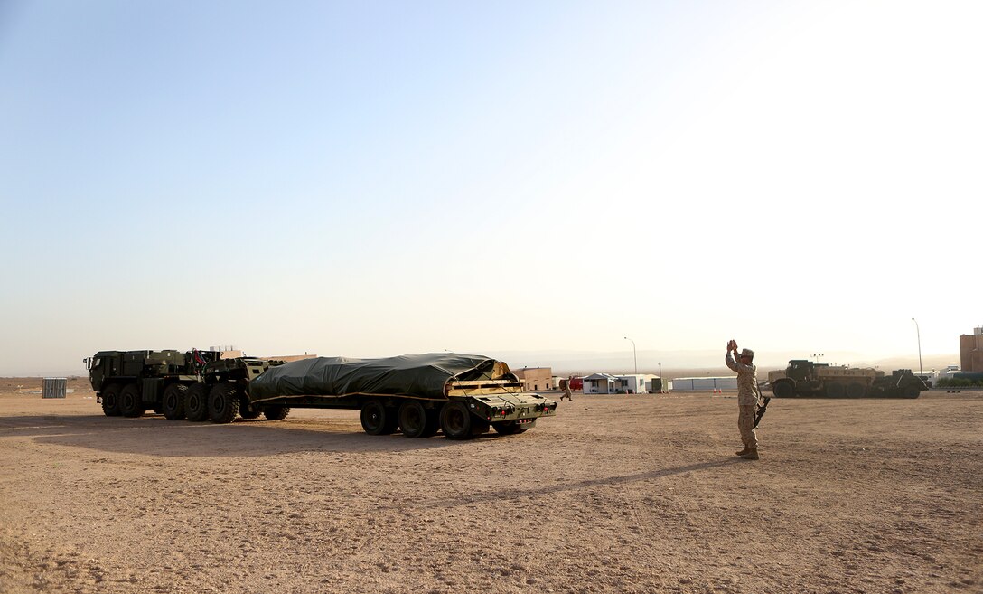 Private First Class Austin Deschler, landing support specialist, Landing Support Company, Headquarters Regiment, 1st Marine Logistics Group, and native of Racine, Wisc., ground guides an armored vehicle to a staging area during Exercise Eager Lion 2014. Eager Lion is a recurring, multinational exercise designed to strengthen military-to-military relationships, increase interoperability between partner nations and enhance regional security and stability.