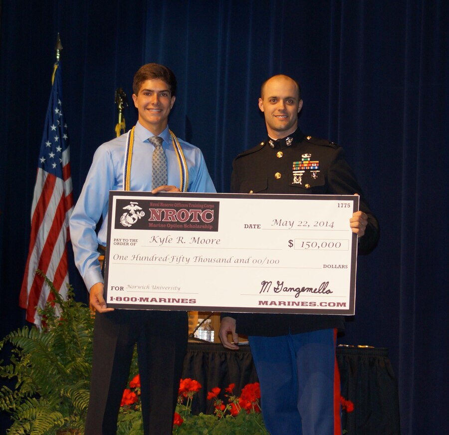 Kyle Moore, a student at Lakeland High School, accepts a $150,000 Naval Reserve Officers Training Corps scholarship presented by U.S. Marine Corps Capt. Michael Gangemella, the executive officer of Recruiting Station Detroit, in front of an auditorium of students, family members and teachers at Lakeland High School May 22, 2014. Moore plans to attend Norwich University in Vermont. Upon completion of his four-year degree in mechanical engineering, Moore will receive his commissioning as a second lieutenant in the U.S. Marines to pursue career opportunities that include pilots, ground combat officers, or a variety of support jobs. (U.S. Marine Corps photo courtesy of Dennis Moore/Released)