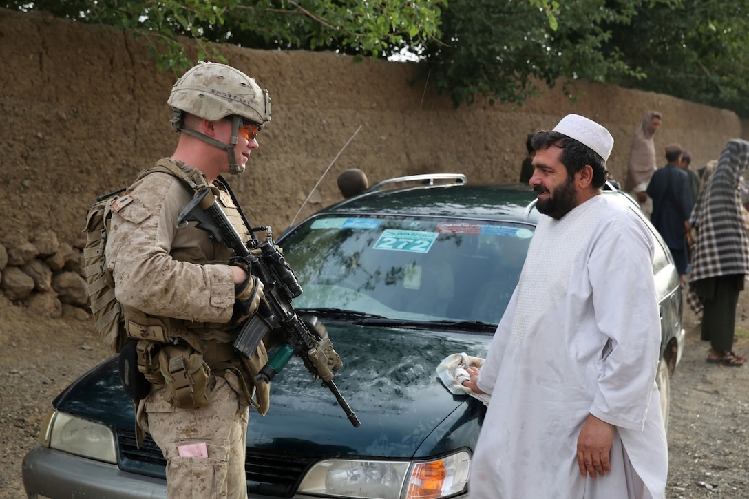 First Lt. Walter Mack, executive officer, Bravo Company, 1st Battalion, 7th Marine Regiment, and a native of New York City, speaks with an Afghan local during a mission in Helmand province, Afghanistan, May 15, 2014. The company operated in Larr Village for two days to establish a presence and to disrupt enemy fighters. Throughout the mission the infantrymen conducted several patrols within the village and discovered hazardous materials which could be used to create improvised explosive devices.