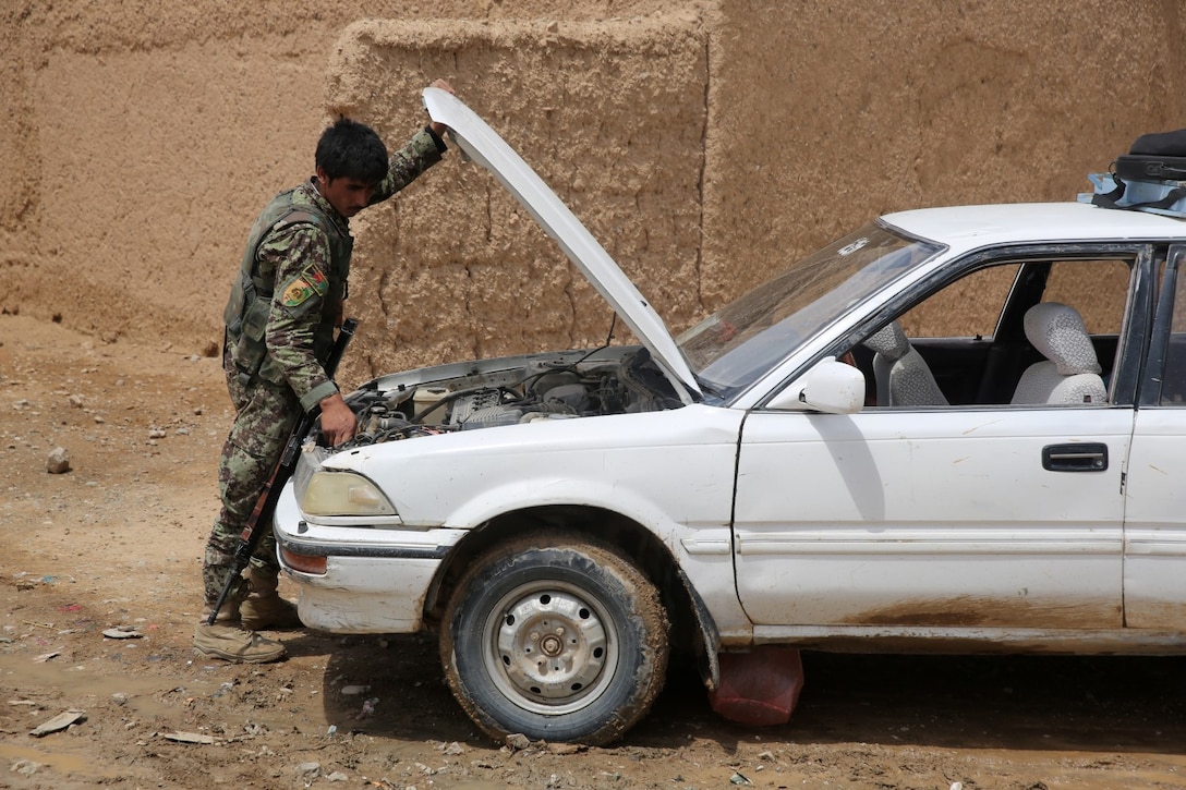 An Afghan National Army soldier searches a vehicle during a partnered patrol with Marines from Bravo Company, 1st Battalion, 7th Marine Regiment, during a mission in Helmand province, Afghanistan, May 15, 2014. The company operated in Larr Village for two days to establish a presence and to disrupt enemy fighters. Throughout the mission the infantrymen conducted several patrols within the village and discovered hazardous materials which could be used to create improvised explosive devices.