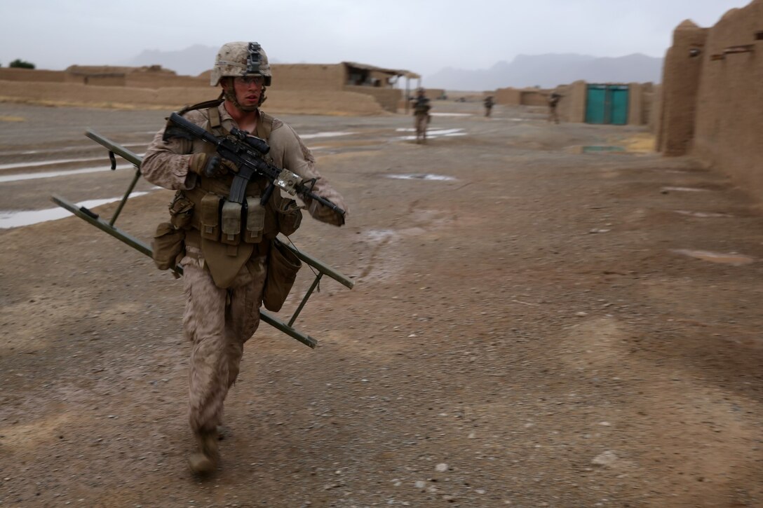 Lance Cpl. Benjamin Knipp, rifleman, Bravo Company, 1st Battalion, 7th Marine Regiment, and a native of Clayton, Ohio, runs to aid Marines with a combat ladder during a mission in Helmand province, Afghanistan, May 15, 2014. The company operated in Larr Village for two days to establish a presence and to disrupt enemy fighters. Throughout the mission the infantrymen conducted several patrols within the village and discovered hazardous materials which could be used to create improvised explosive devices.