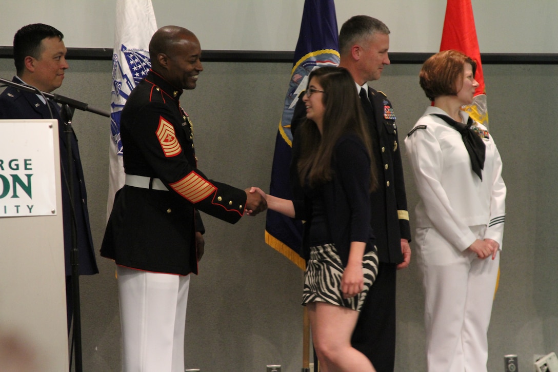 U.S. Marine Corps Sgt. Maj. Mark A. Byrd Sr., a Pontiac, Michigan, native and the sergeant major of Marine Corps Base Quantico, shakes hands with future Marine recruit Nina Garrido, an Ashburn, Virginia native, recognizing her commitment to enlist directly out of high school at the Our Community Salutes Northern Virginia Chapter recognition ceremony at George Mason University in Fairfax, Virginia, May 29, 2014. Our Community Salutes Northern Virginia Chapter is an all-volunteer organization that recognizes young men and women who have chosen to join the military immediately following high school graduation. Our Community Salutes started in New Jersey in 2009 and has since spread throughout the country.