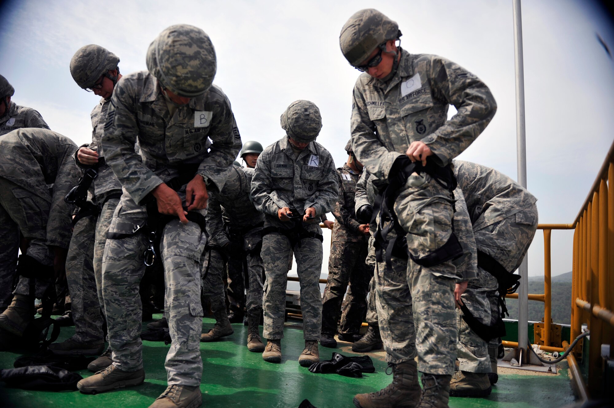 Members of the 51st Security Forces Squadron put on harnesses before repelling off of a training building during the Republic of Korea Ranger Qualification Course on Jinju Air Base, ROK, May 27, 2014. Members completed basic repelling training during the first week. (U.S. Air Force photo/Senior Airman David Owsianka)