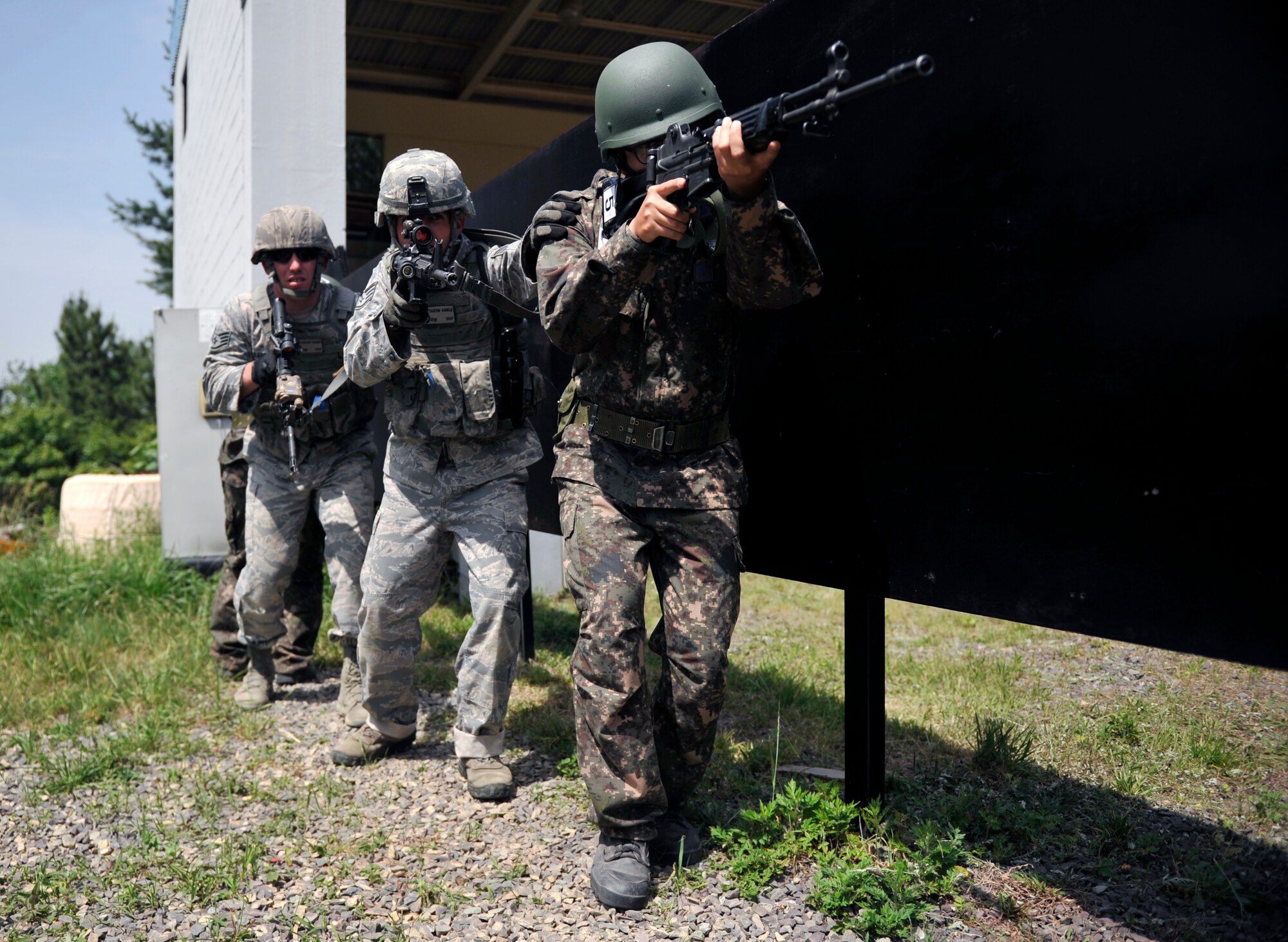 Republic of Korea air force airmen and U.S. Air Force security forces Airmen move together at the start of a close quarter combat scenario during the ROK Ranger Qualification Course on Jinju Air Base, ROK, May 27, 2014. The Airmen completed the scenarios in four- to six-man teams. (U.S. Air Force photo/Senior Airman David Owsianka)