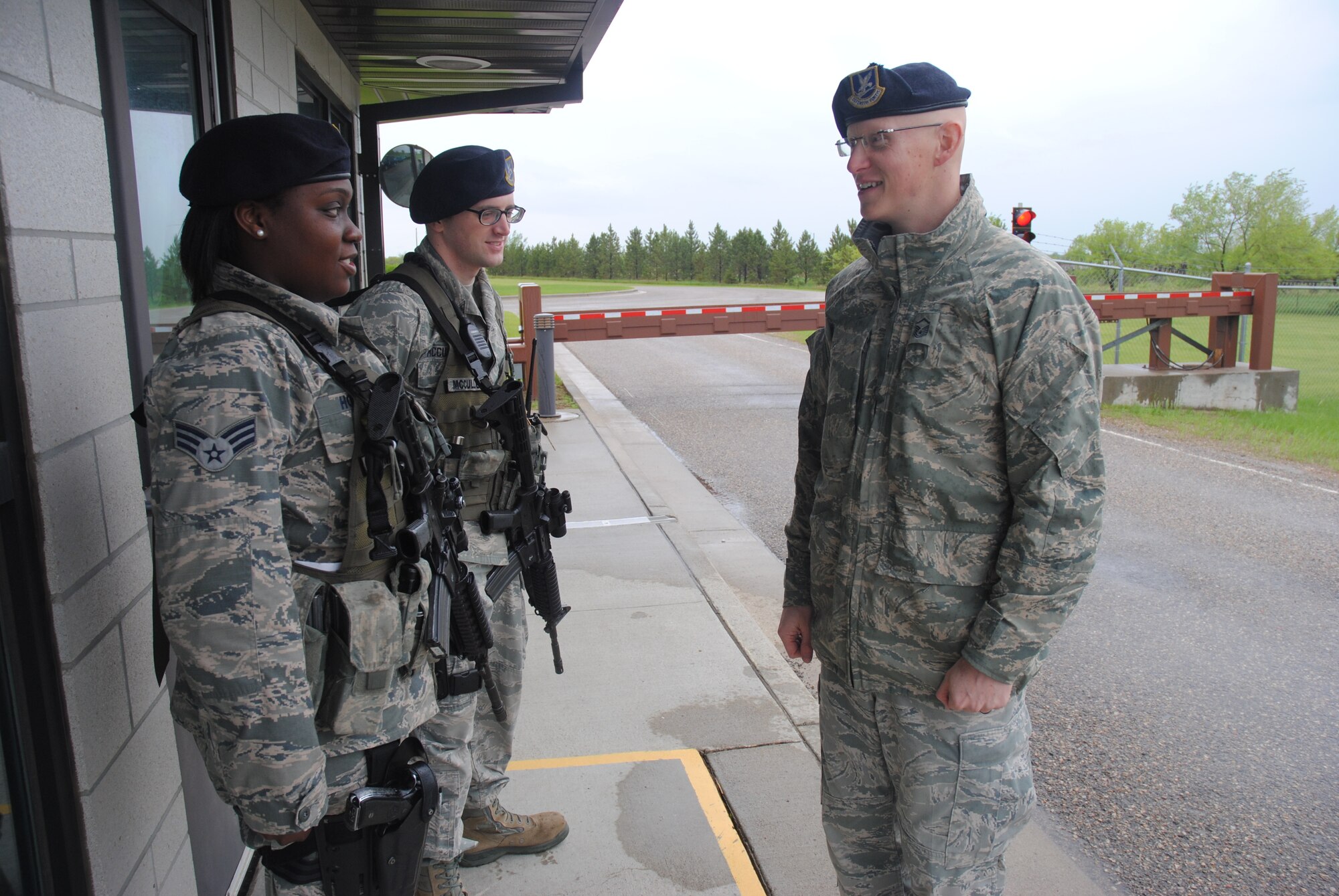 Entry controller Senior Airman Jennetta Howard and patrolman Senior Airman Matthew McCulloch exchanges pleasantries with Master Sgt. Shane M. Sudman, 10th Space Warning Squadron superintendent of security forces, after a post briefing at the main gate of Cavalier Air Force Station, N.D., on June 2, 2014. Sudman, a 14-year Air Force veteran from Nebraska City, Neb., uses casual conversations with subordinates during work shifts in order to learn more about the Airmen he leads and create opportunities for mentorship and personal development. (U.S. Air Force photo/Staff Sgt. Luis Loza Gutierrez) 
