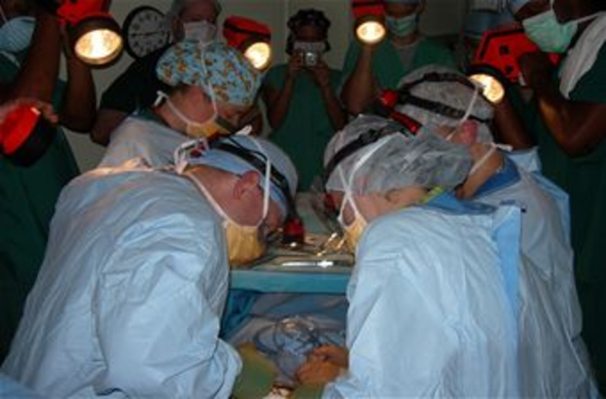 Industrial flashlights are used to illuminate the surgical field for the baby’s
C-section delivery during Hurricane Katrina. (Photo by retired Maj. Betsy Majma)