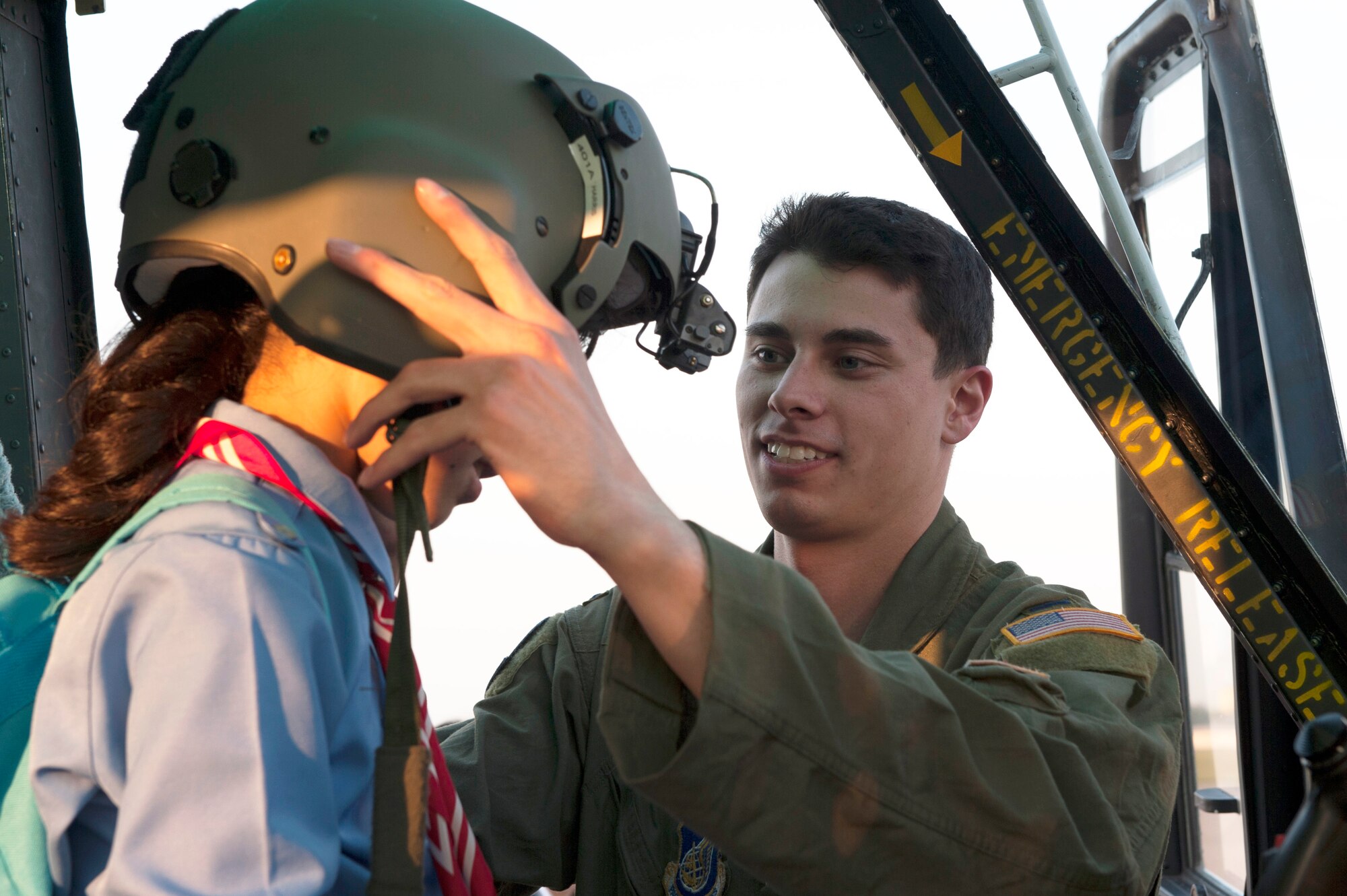 1st Lt. Daniel Trapani, 459th Airlift Squadron scheduler, places a helmet on a Japanese Girl Scout May 30, 2014, at Yokota Air Base, Japan. U.S. and Japanese Girl Scouts learned about the C-130 Hercules, C-12 Huron and UH-1N Huey during Military SHeroes Day. (U.S. Air Force photo by Senior Airman Desiree Economides)