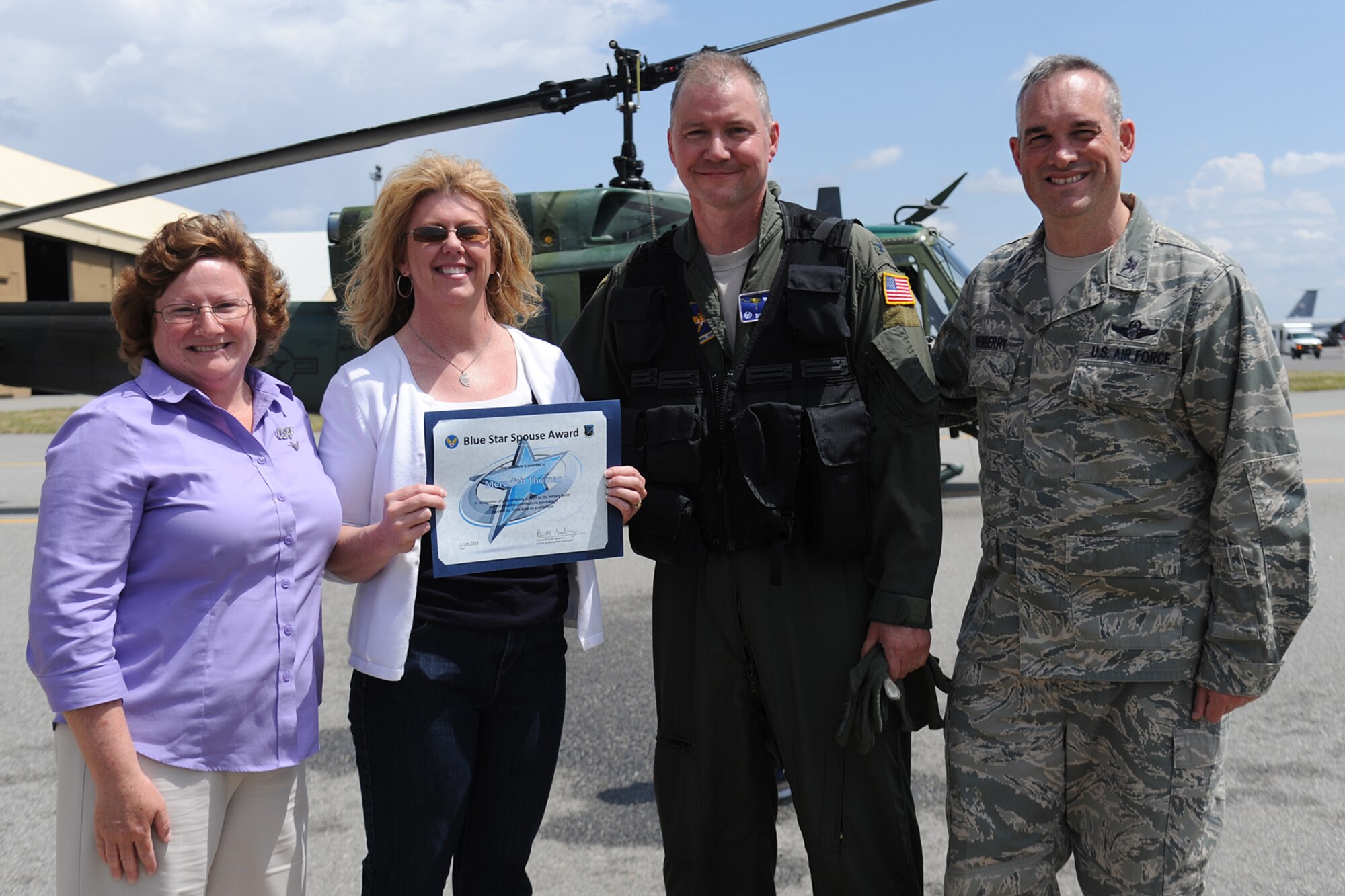 Col. Brian Newberry and his wife, Jill, present the Blue Star Spouse Award to Meredith Thomas, Col. William “Bill” Thomas’ wife, June 3, 2014. The award is presented to Fairchild spouses for their commitment to excellence and support to the Fairchild family. Newberry said, “Mrs. Thomas' absolutely amazing support for honoring and supporting the Exceptional Family Members on base was inspiring.” Anyone interested in nominating someone for the Blue Star Spouse Award should contact their squadron commander. Newberry is the 92nd Air Refueling Wing commander and Thomas is the 336th Training Group commander. (U.S. Air Force photo by Airman 1st Class Janelle Patiño/Released)