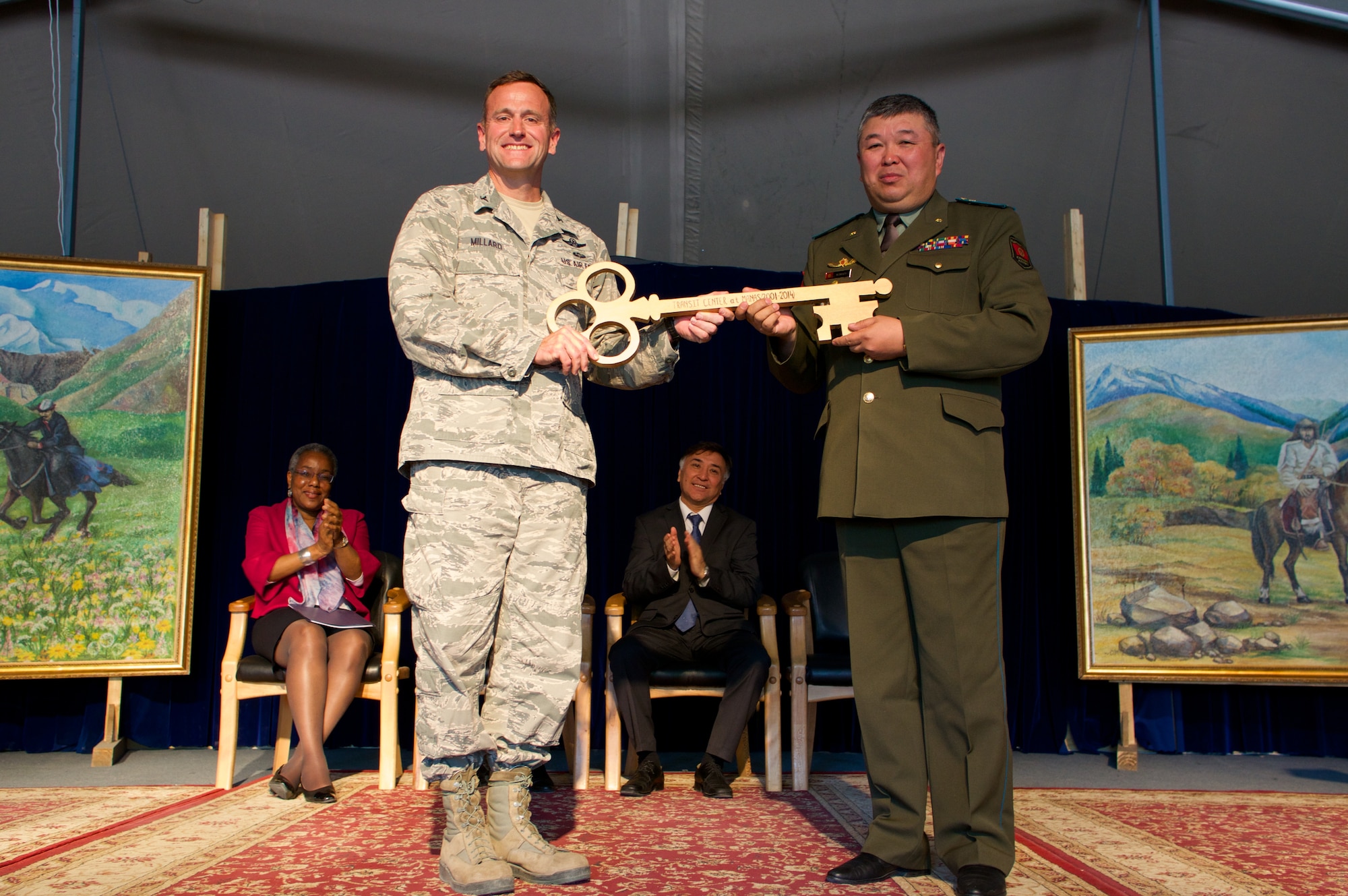 Col. John Millard, Director of the Transit Center at Manas, Kyrgyzstan, and Col. Mirbek Imayev, Chief of Staff of the Kyrgyz National Guard, pose with a symbolic golden key signifying the transfer of control of the Transit Center from the United States to the Kyrgyz government. The facility stood up 12 and a half years ago after the terrorist attacks in America on Sept. 11, 2001. The center was the premier transportation and logistics hub supporting combat operations for Operation Enduring Freedom. (Photo courtesy of Capt. Cory O'Brien)