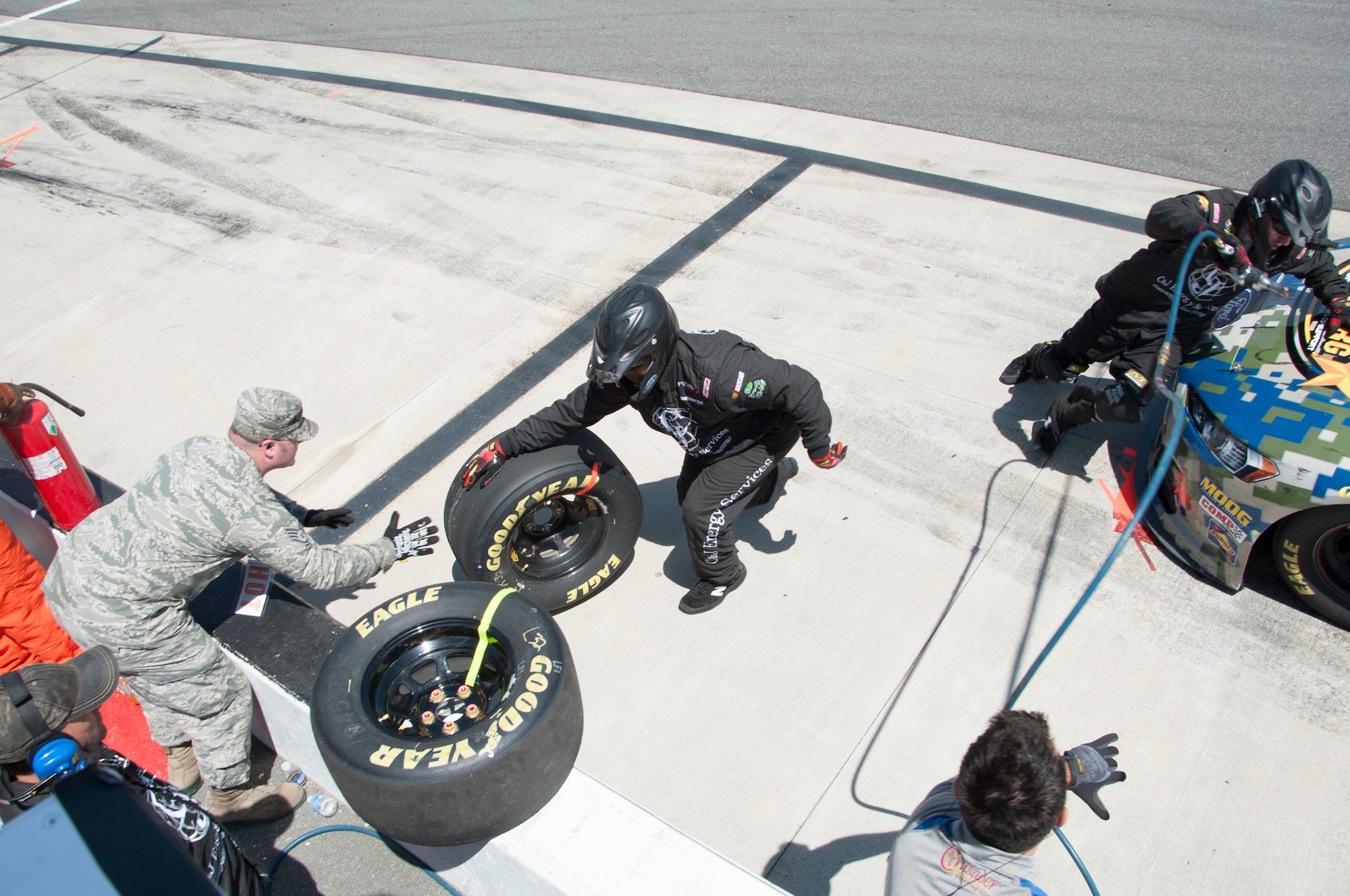 Staff Sgt. Corydon Thomas, 436th Aerial Port Squadron passenger service supervisor, receives a tire from the pit crew of Blake Koch, driver of the No. 32 C & J Energy Ford, FedEx 400 June 1, 2014, at Dover International Speedway in Dover, Del. Thomas was one of many Team Dover members chosen to be honorary pit crew members. (U.S. Air Force photo/Senior Airman Jared Duhon)