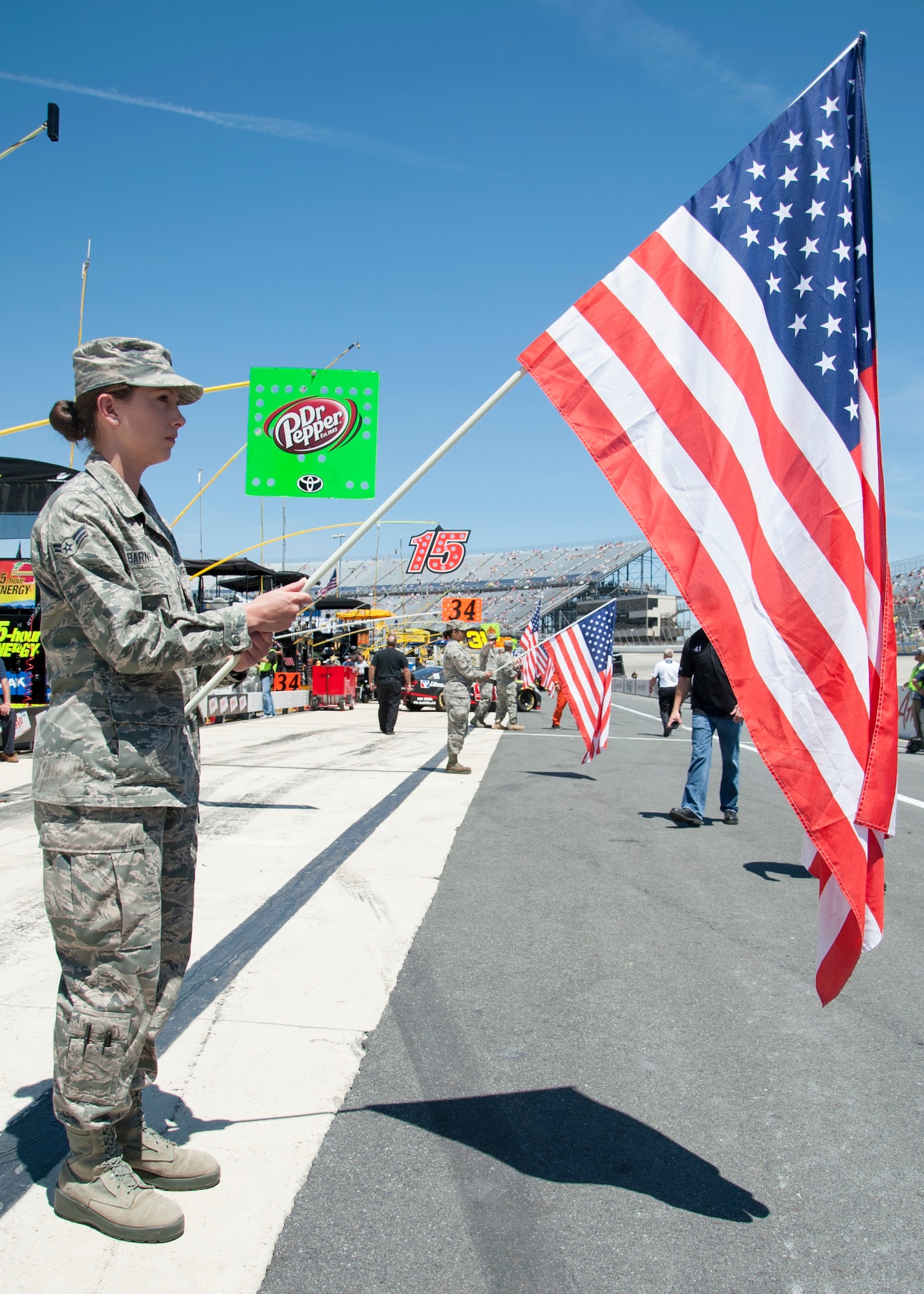 Airman 1st Class Rikki Barnett, Delaware Air National Guard 147th Aero Medical Squadron, holds the U.S. flag during the pre-race ceremonies before the start of the FedEx 400 June 1, 2014, at Dover International Speedway in Dover, Del. The Delaware National Guard participated in a variety of activities in support of race weekend. (U.S. Air Force photo/Senior Airman Jared Duhon) 