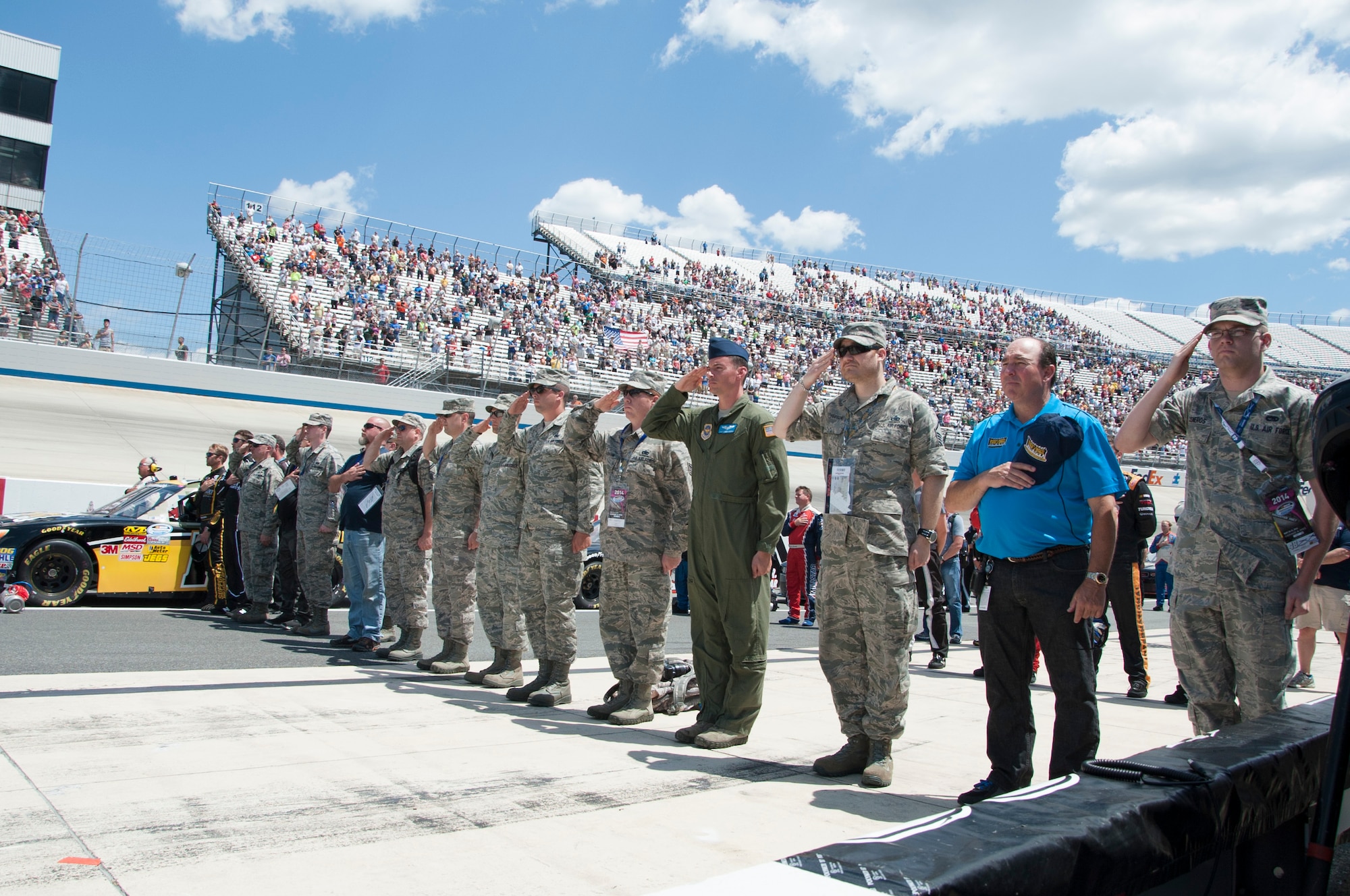 Honorary pit crew members salute during the singing of the National Anthem before the start of the Camping World Truck Series race, May 30, 2013, at Dover International Speedway in Dover, Del. The Airmen were honorary pit crew members for Blake Koch, driver of the No. 10 Greg Pollex Toyota, and were able to spend time with his pit crew and watch the race from his pit box. (U.S. Air Force photo/Senior Airman Jared Duhon)