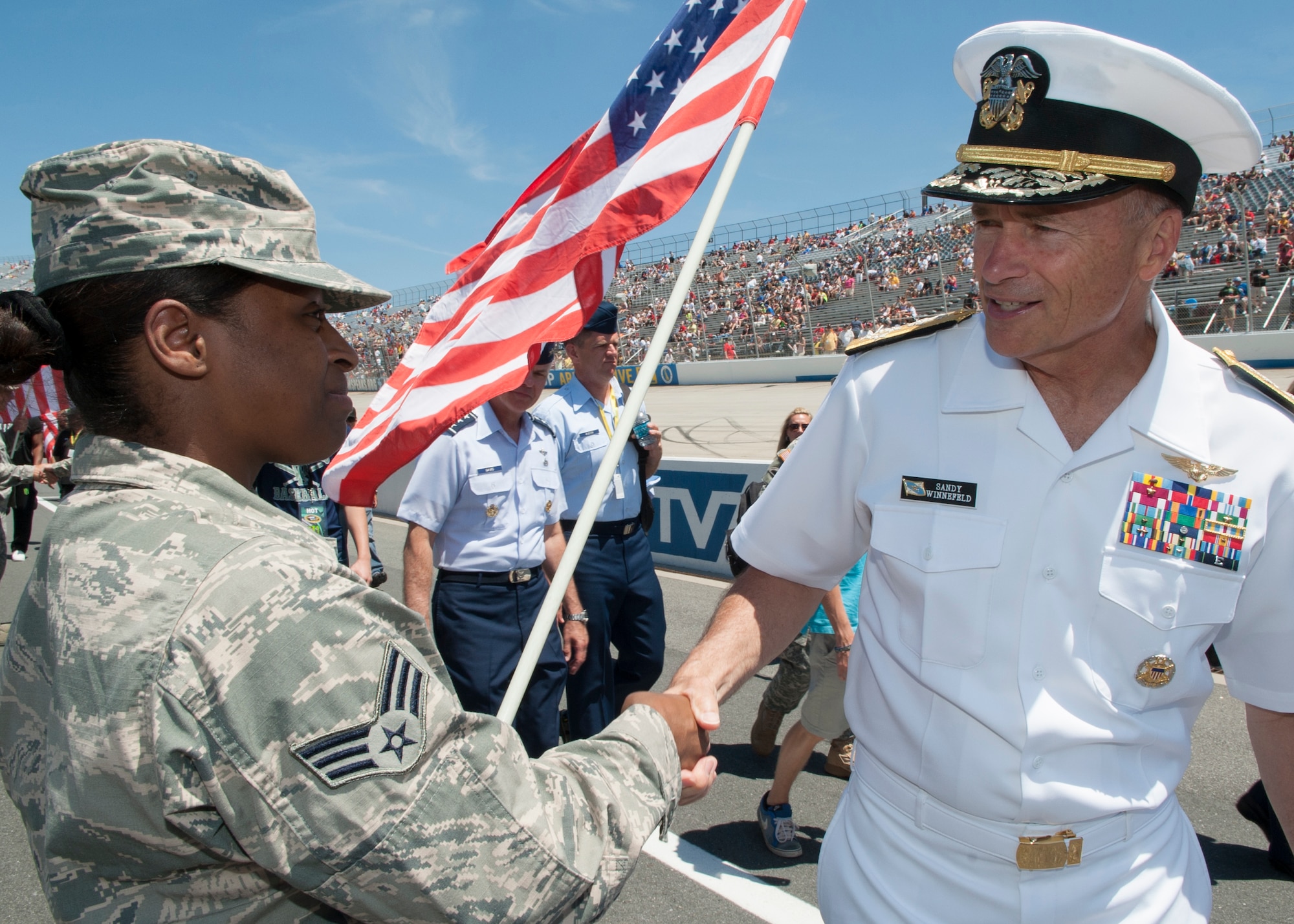 Adm. James A. Winnefeld, Jr., Vice Chairman of the Joint Chiefs of Staff, shakes an Airman’s hand before the start of the NASCAR Sprint Cup Series FedEx 400 benefiting Autism Speaks June 1, 2014, at Dover International Speedway in Dover, Del. Adm. Winnefeld presented coins to countless Airmen and each driver in the race. (U.S. Air Force photo/Airman 1st Class Zachary Cacicia)