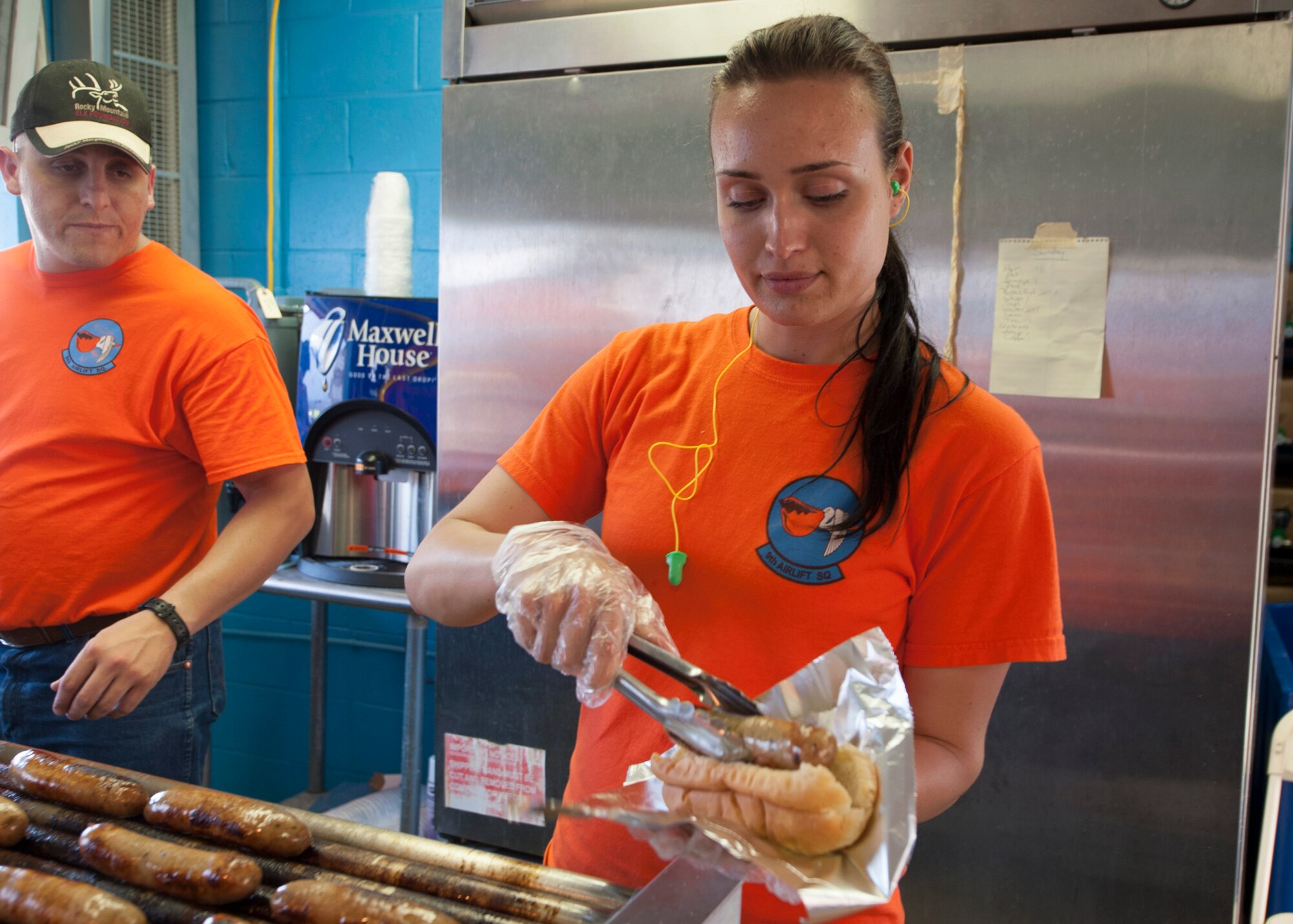 Staff Sgt. Paige Wentland, 9th Airlift Squadron flight engineer, prepares food for a customer during the FedEx 400 June 1, 2014, at Dover International Speedway in Dover, Del. Wentland is a part of the 9th AS’s booster club which uses NASCAR events as a way to raise funds. (U.S. Air Force photo/Senior Airman Jared Duhon)
