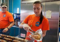 Staff Sgt. Paige Wentland, 9th Airlift Squadron flight engineer, prepares food for a customer during the FedEx 400 June 1, 2014, at Dover International Speedway in Dover, Del. Wentland is a part of the 9th AS’s booster club which uses NASCAR events as a way to raise funds. (U.S. Air Force photo/Senior Airman Jared Duhon)