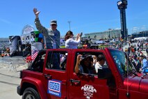 Col. Rick Moore, 436th Airlift Wing commander, and wife, Kristin Moore, wave to NASCAR fans June 1, 2014, at the Dover International Speedway in Dover, Del. Col. Moore and other senior leaders of Dover Air Force Base rode in the parade lap before the start of the FedEx 400 race. (U.S. Air Force photo/Airman 1st Class William Johnson)